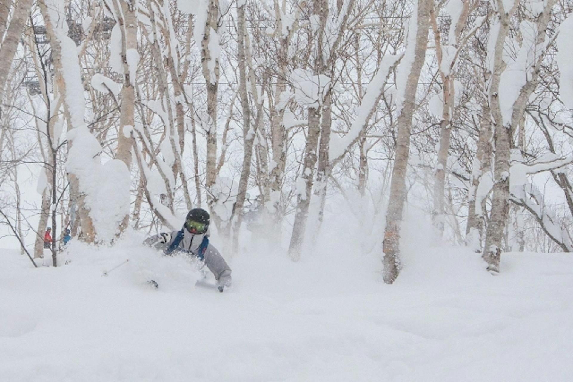 A skier skiing in powder snow in Japan.