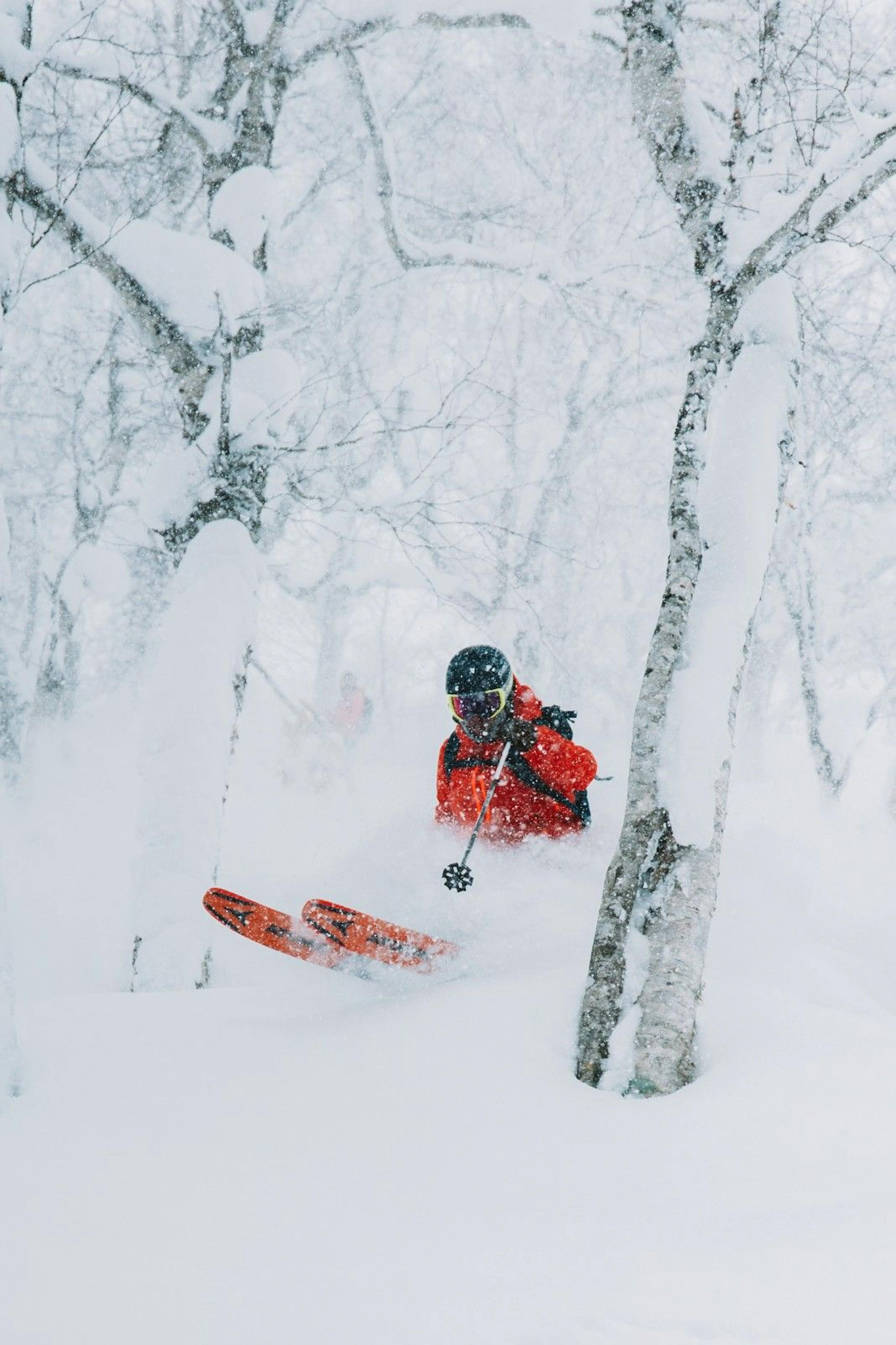 A skier skiing in powder snow in Japan.