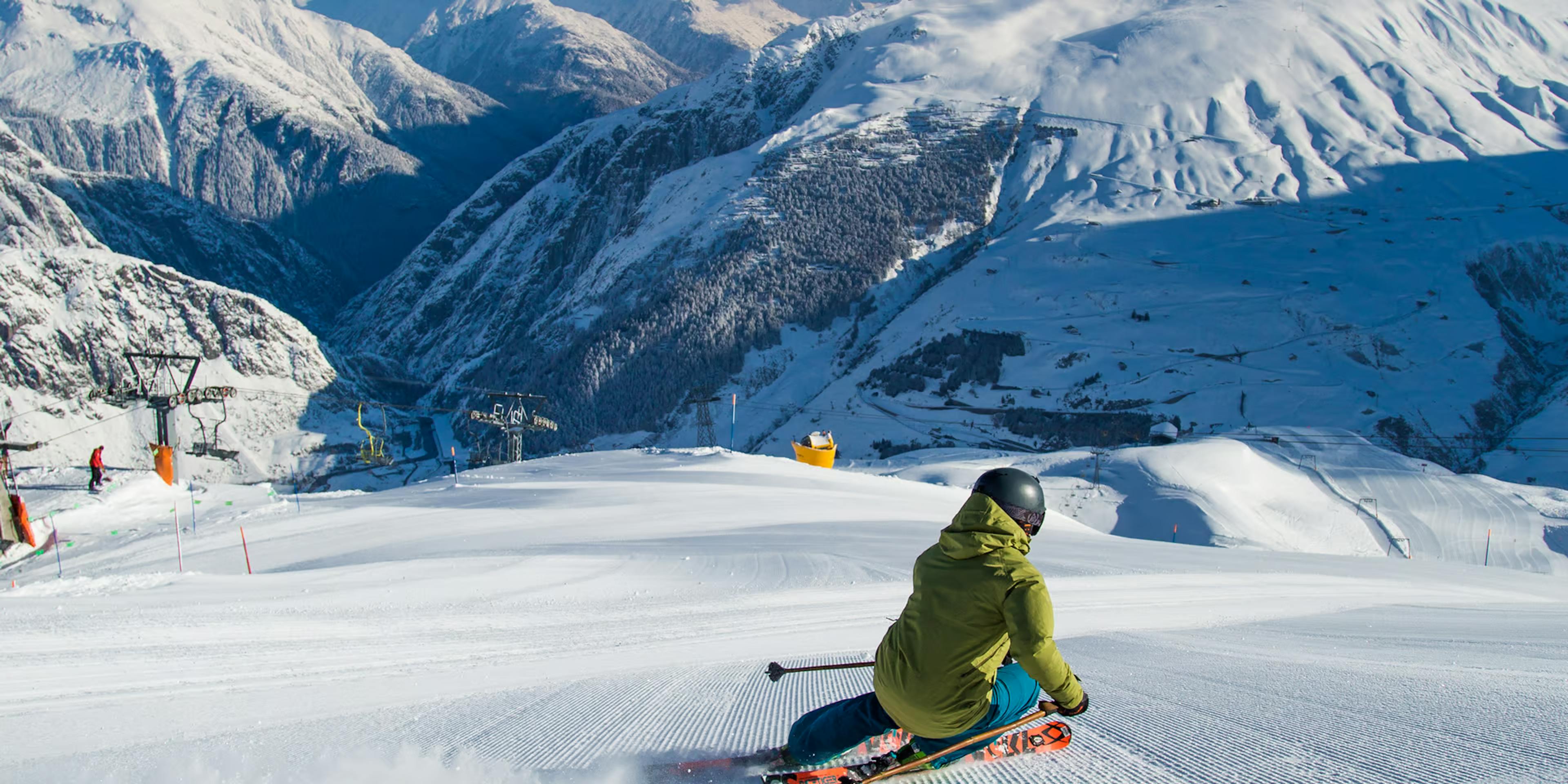 a skier heads down a run of smooth corduroy at Andermatt-Sedrun ski resort