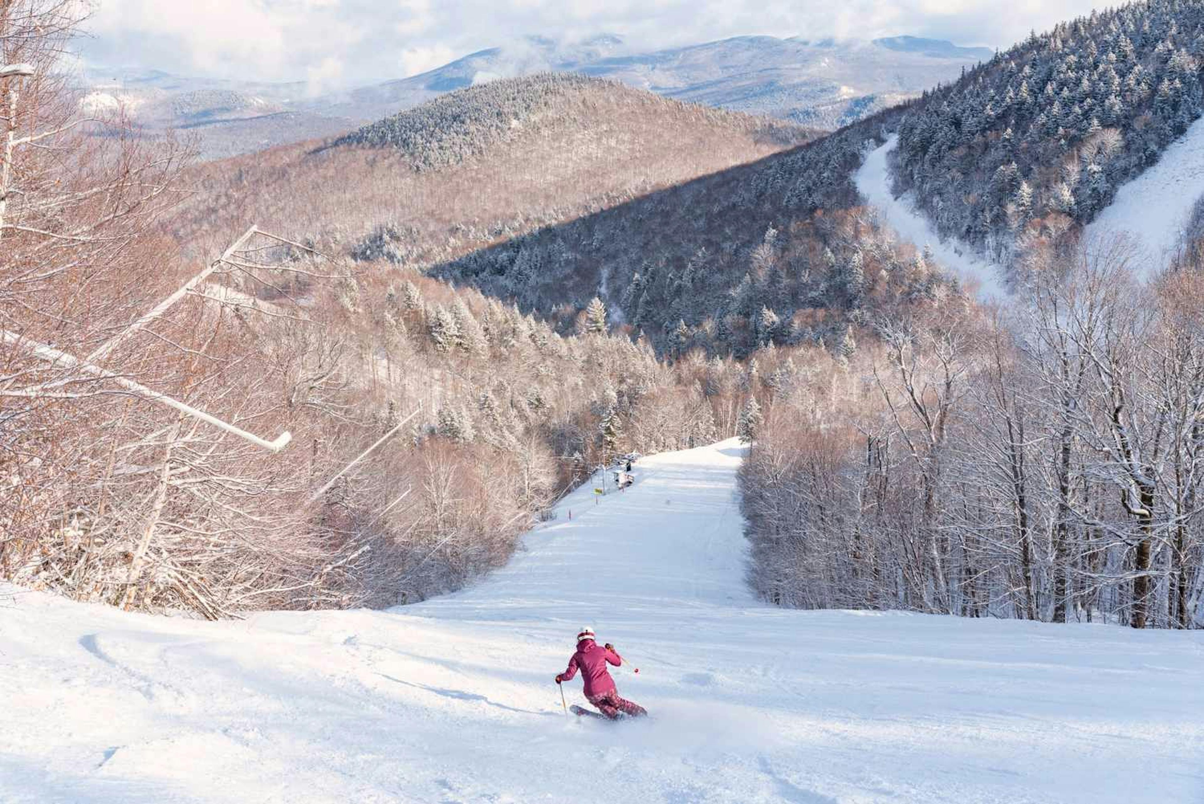 A female skier skiing down Sunday River.