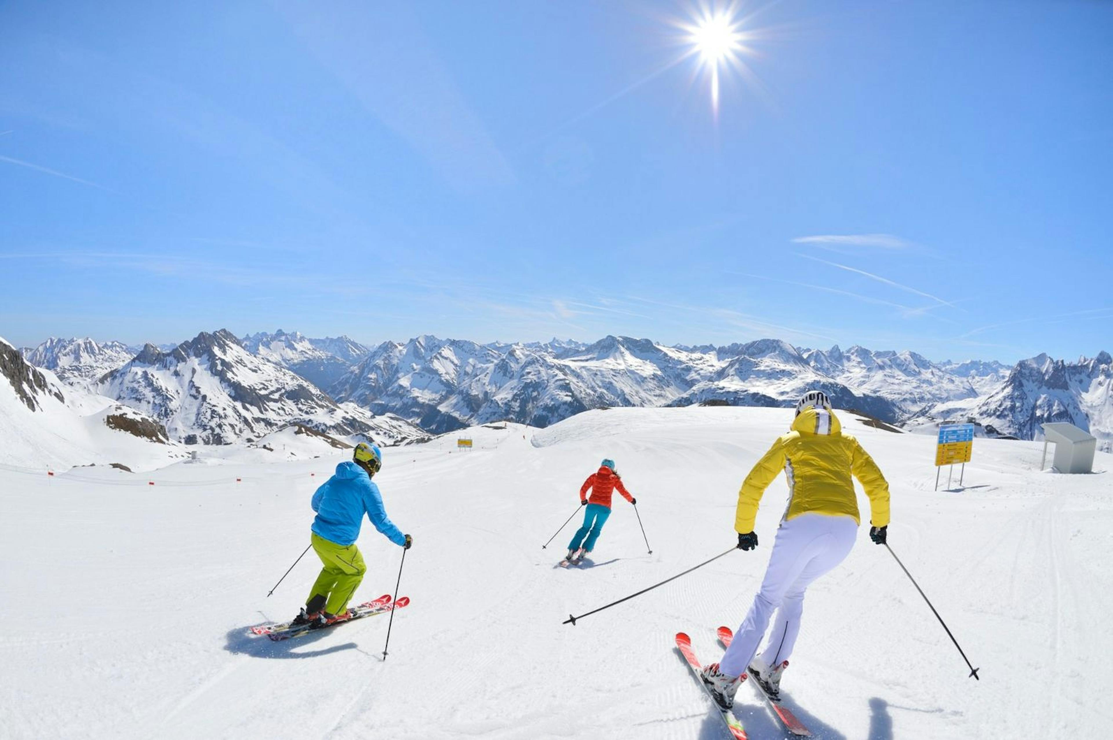 Skiers skiing on a sunny day in Lech, Austria. 