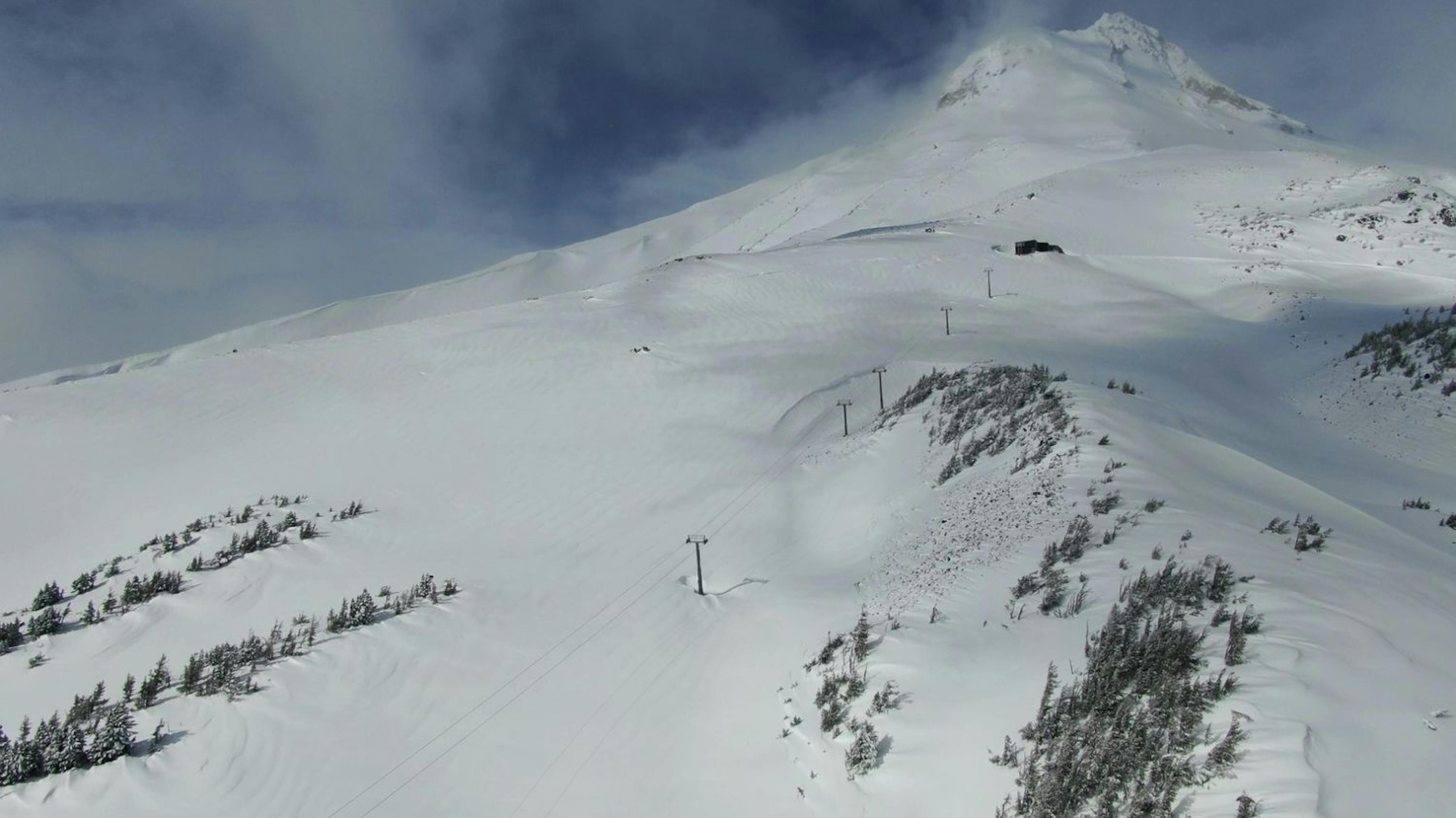 Snow-covered Mt. Hood with a ski lift ascending its slopes, perfect for winter sports enthusiasts and nature lovers.