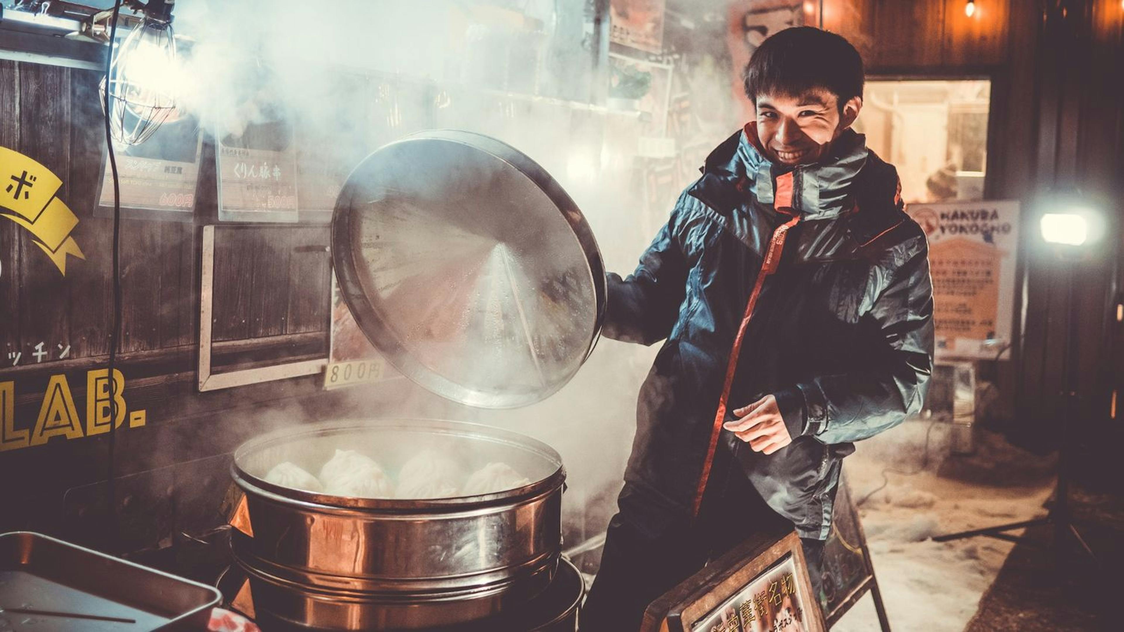 A man cooks a delicious meal in a pot on the stove, surrounded by the beautiful scenery of Hakuba.