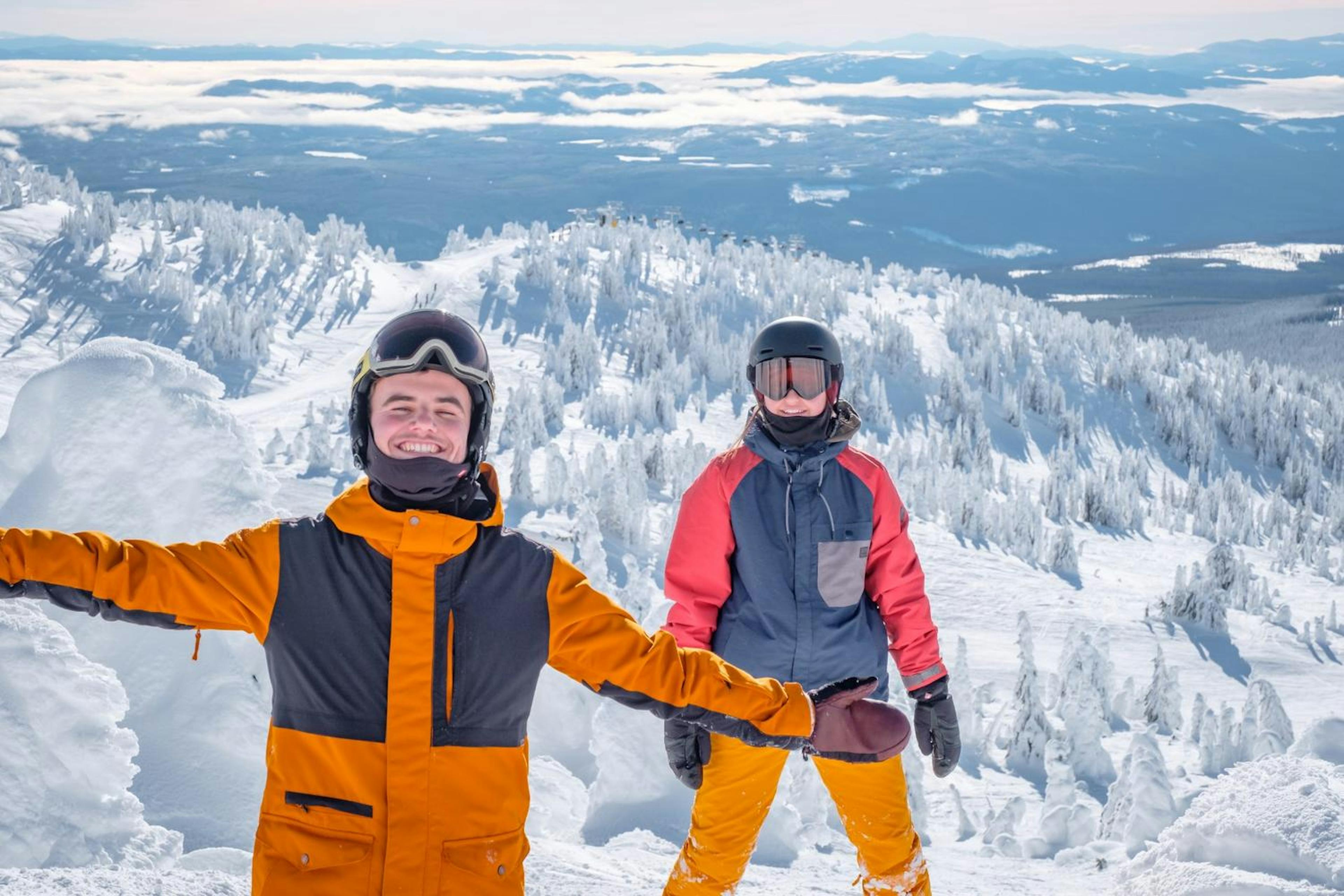 Two friends stand on a snowy mountain at Big White Ski Resort