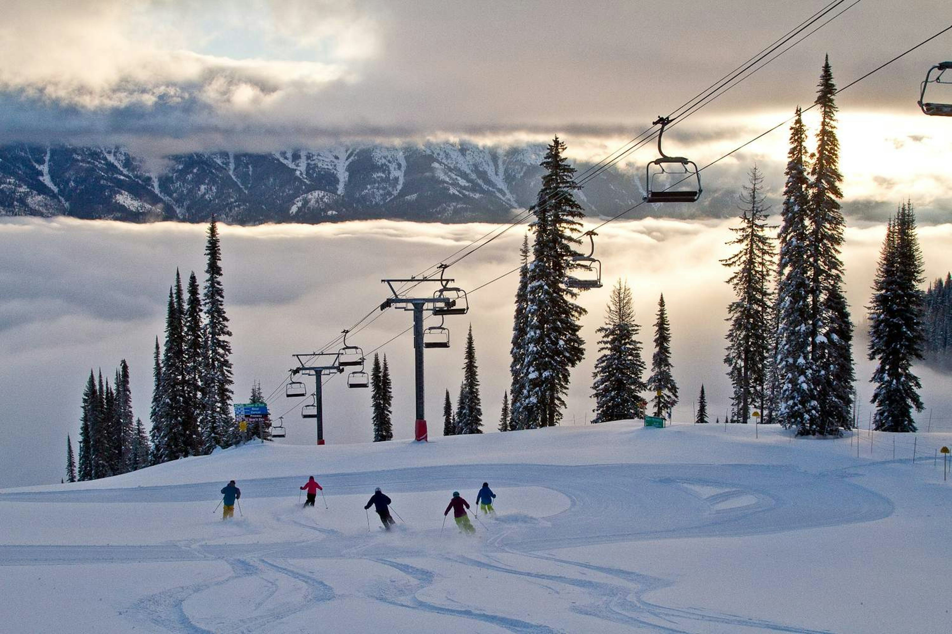 A group of skiers enjoying descent on a snowy slope at Fernie Alpine Resort.