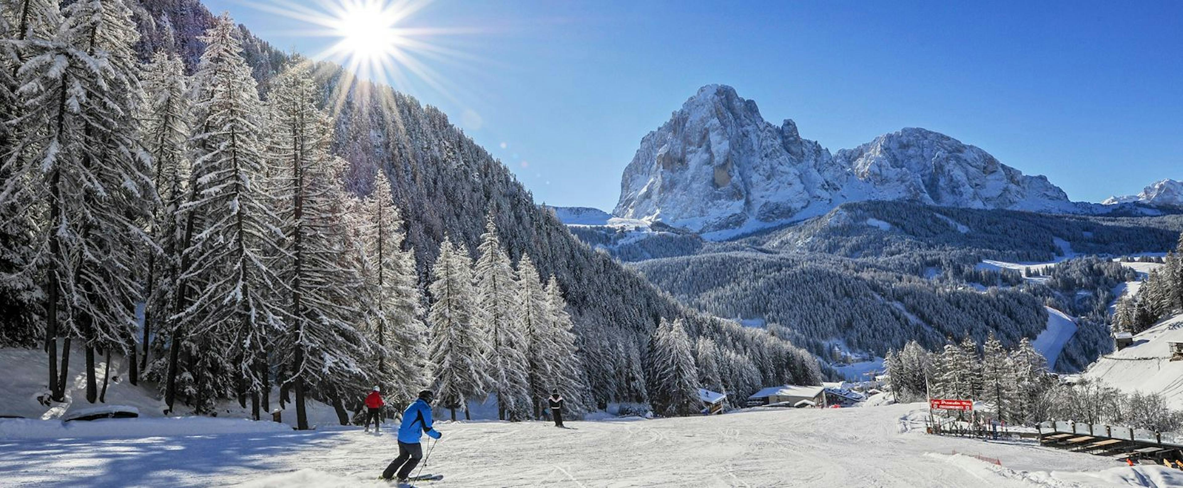 Skier in blue jacket skiing the slopes at Val Gardena in the morning