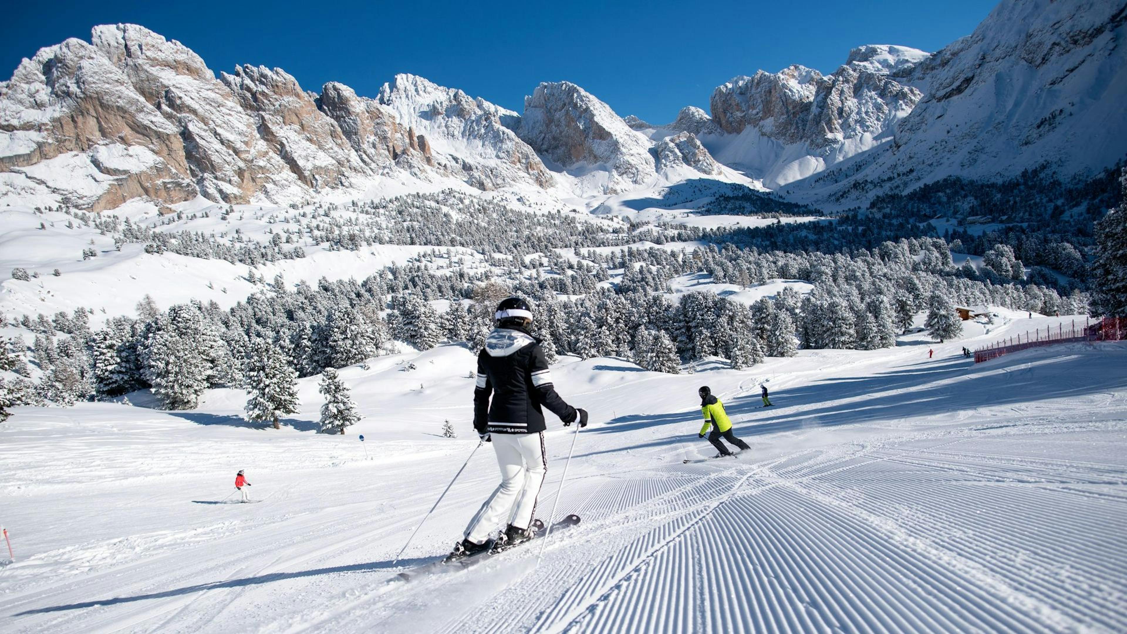 Two skiers skiing fresh corduroy at Val Gardena