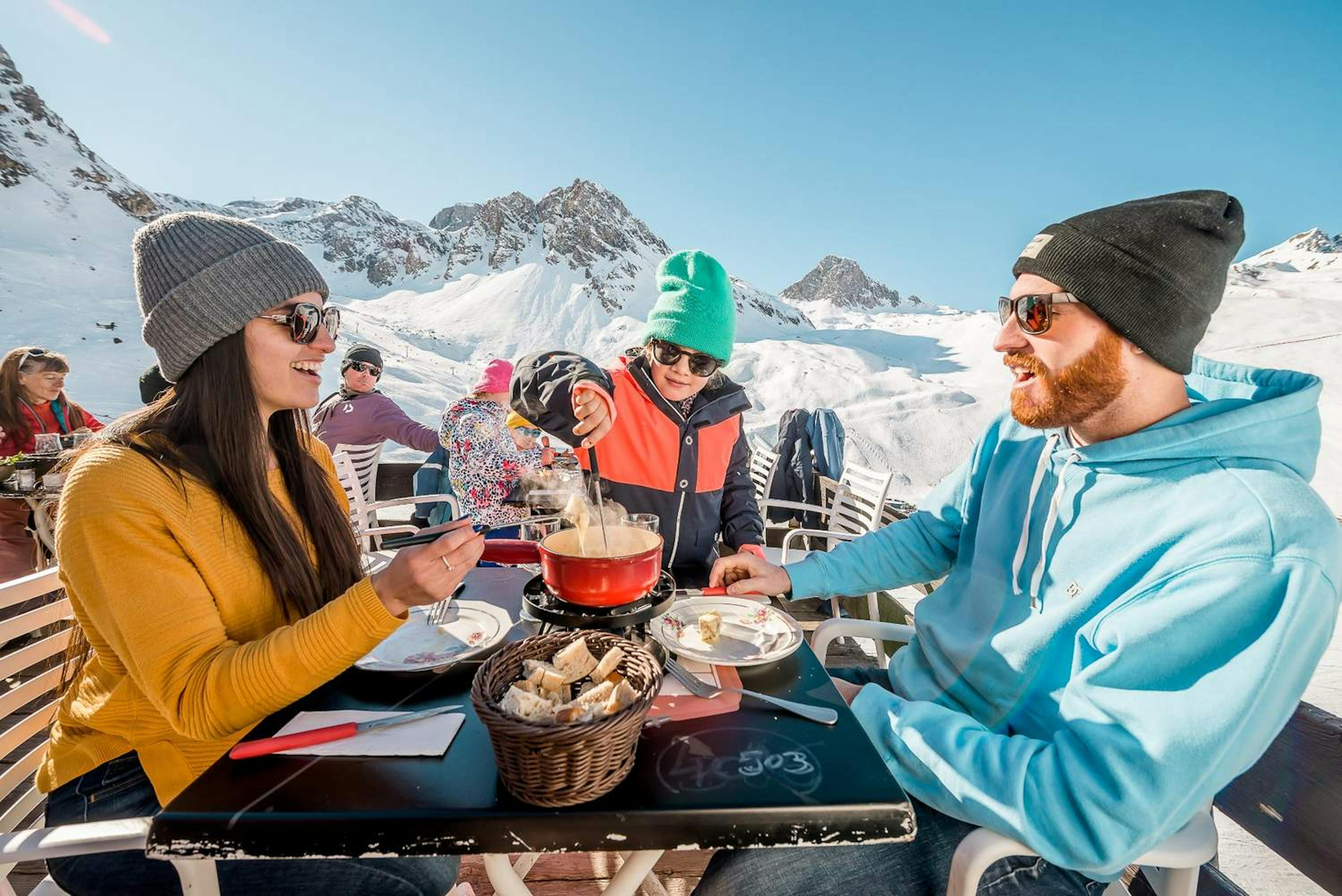 A family sharing a delicious meal together at a cozy restaurant in Tignes.