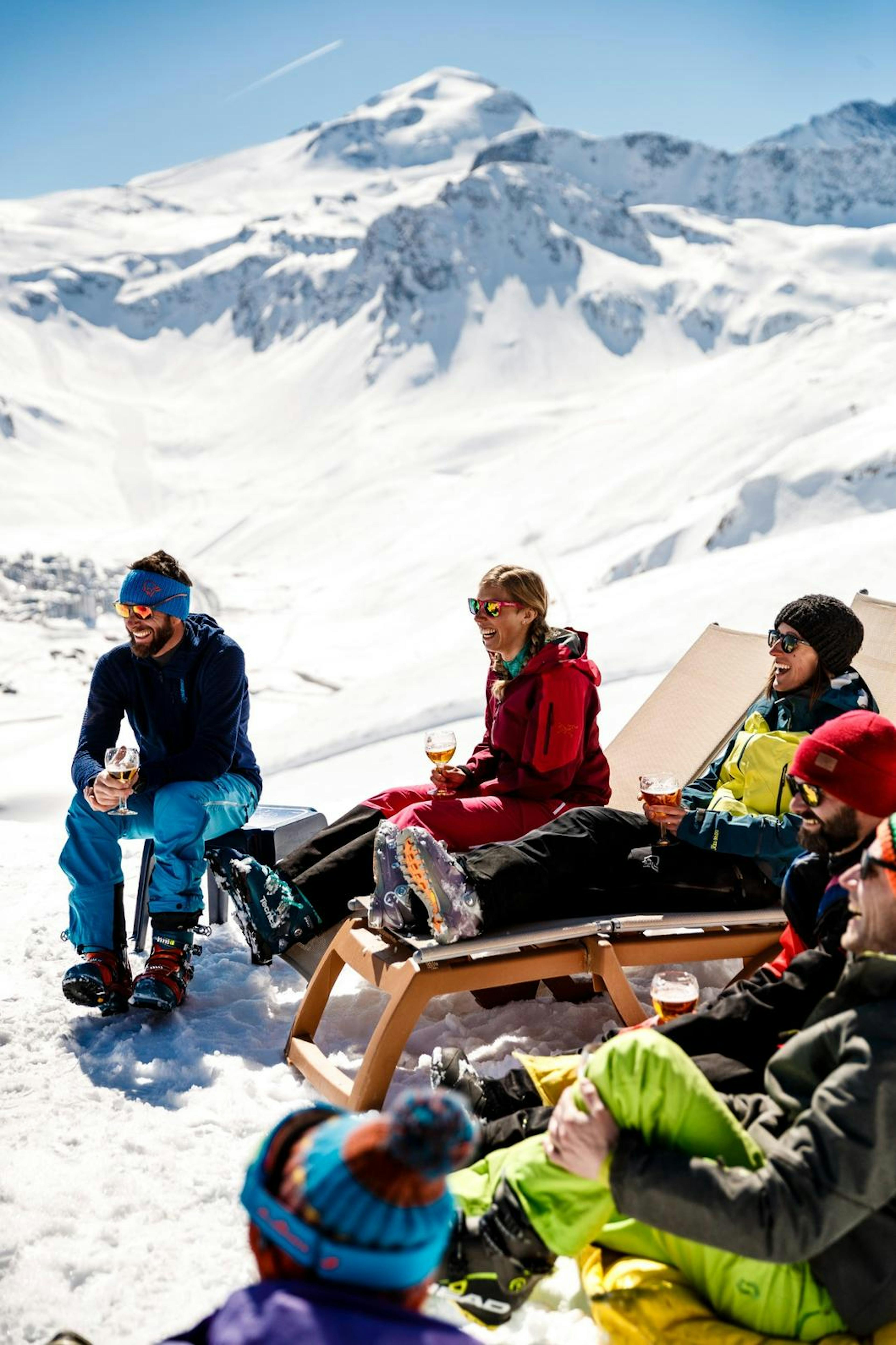 A group of friends enjoying a sunny day on a snow-covered hill in Tignes, surrounded by winter wonderland vibes.