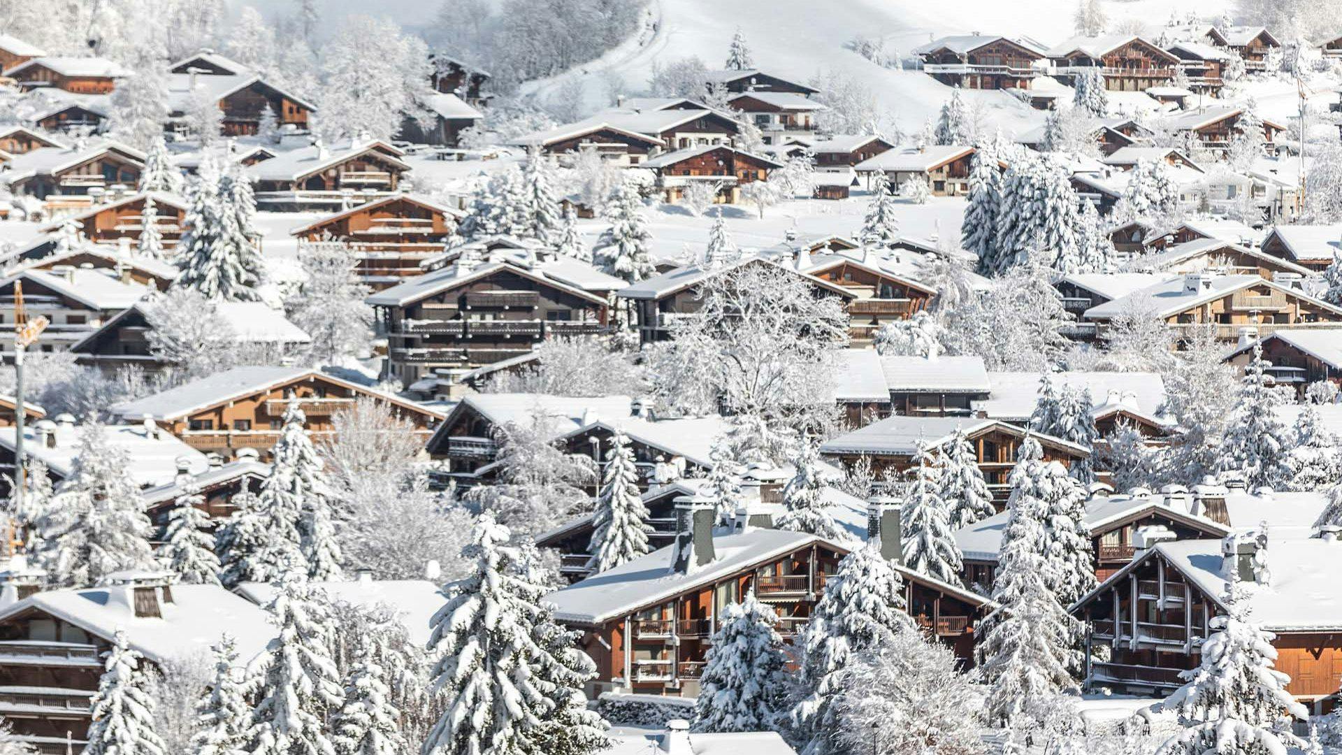 ski in ski out chalets in megeve france with snow covered roofs and trees