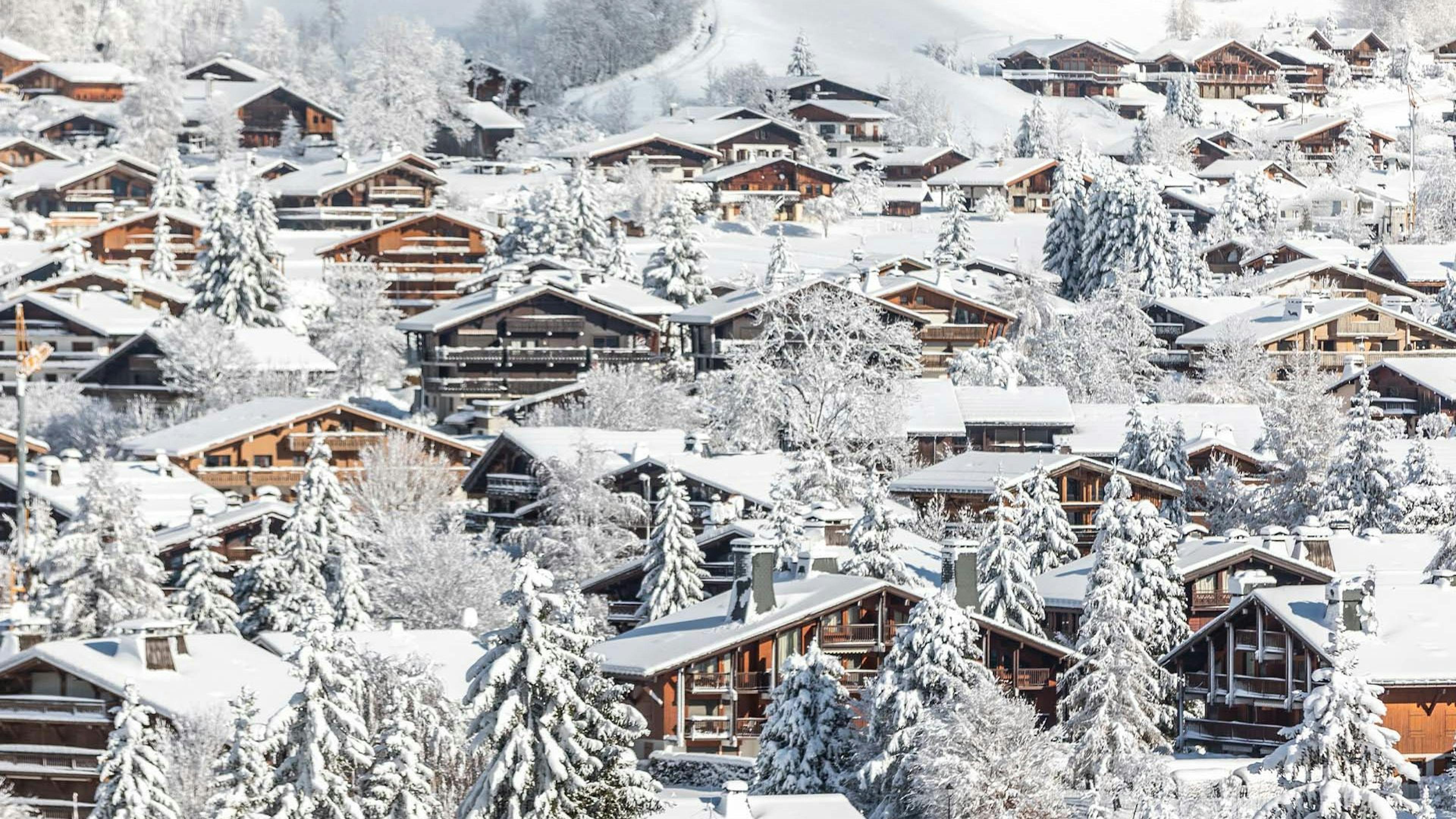 ski in ski out chalets in megeve france with snow covered roofs and trees