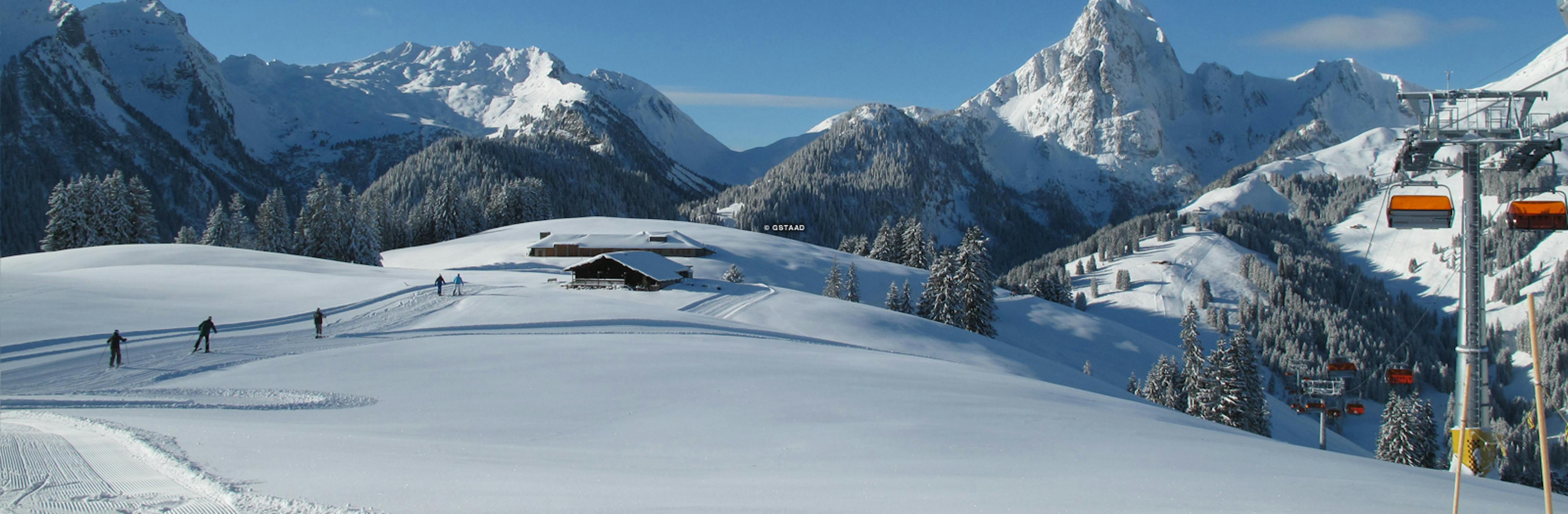 wide angle shot of the lifts in gstaad Switzerland with the lift system and large swiss peaks in the background

