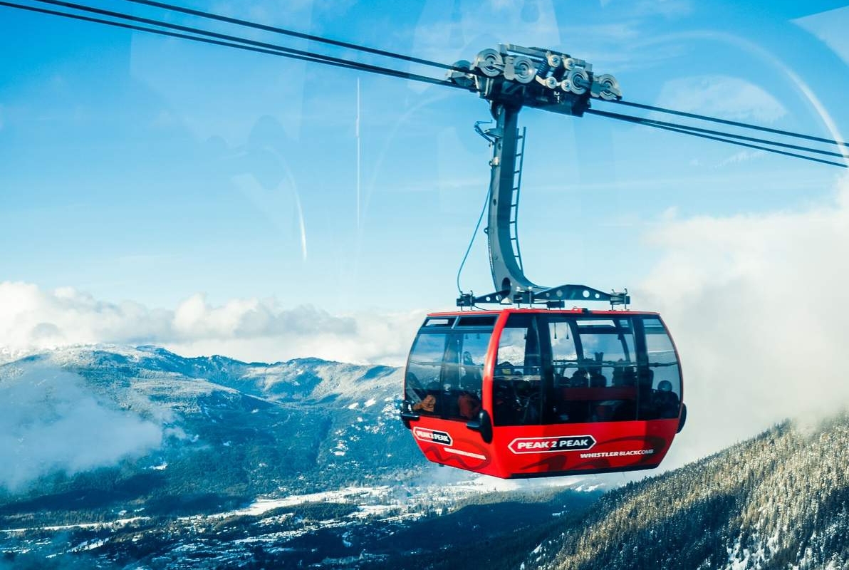 A cable car glides above the stunning mountain range of Whistler Blackcomb ski resort