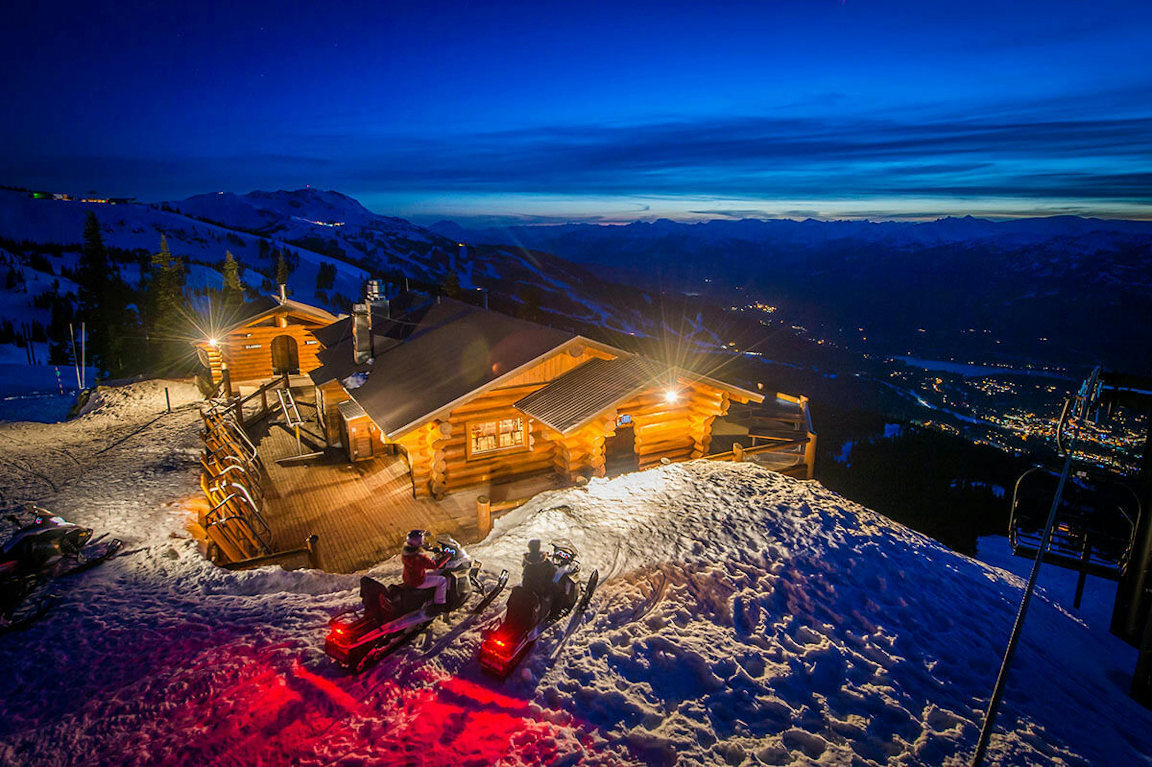 A charming ski lodge in Whistler, with snowmobiles lined up outside