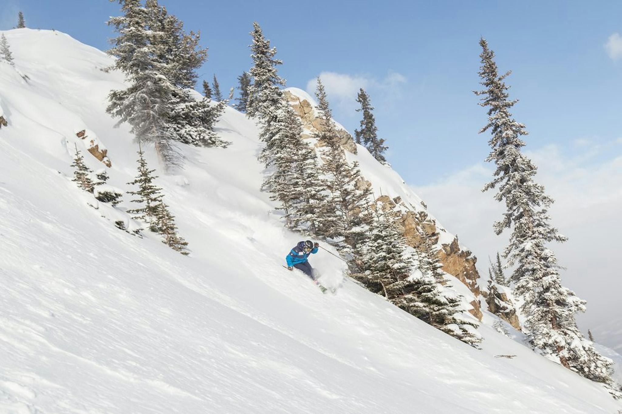 Man in blue jacket skiing the slopes of Marmot Basin