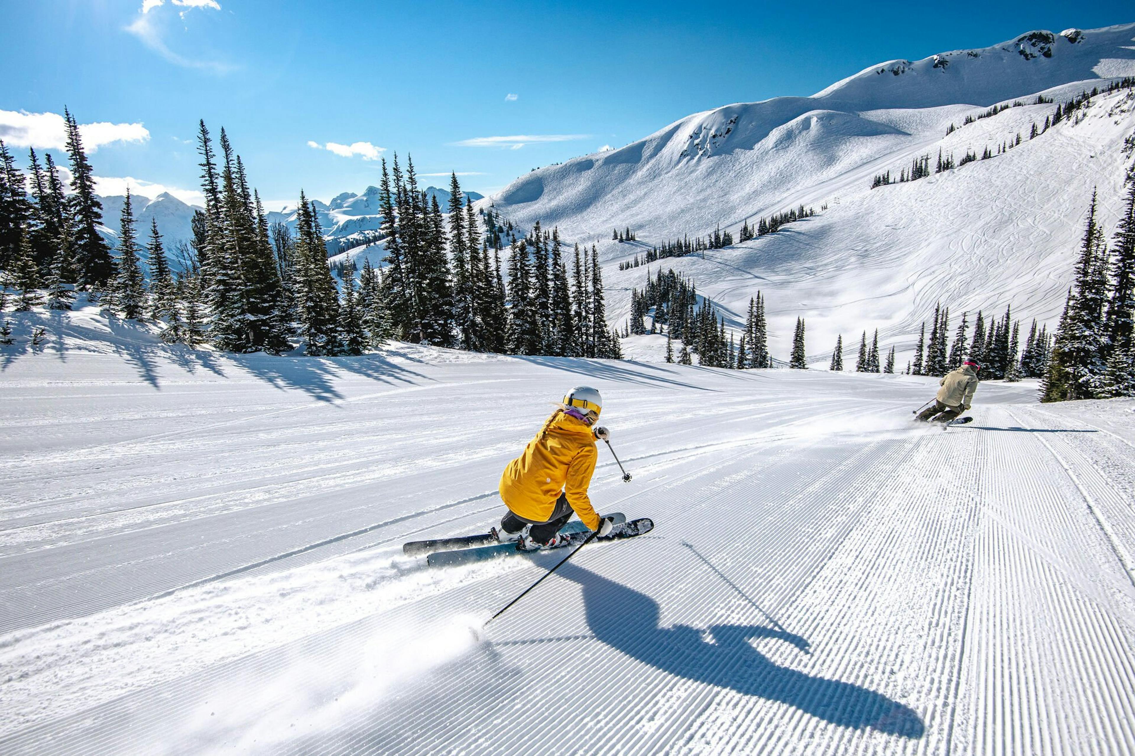 Two skiers skiing the fresh corduroy at Whistler Blackcomb