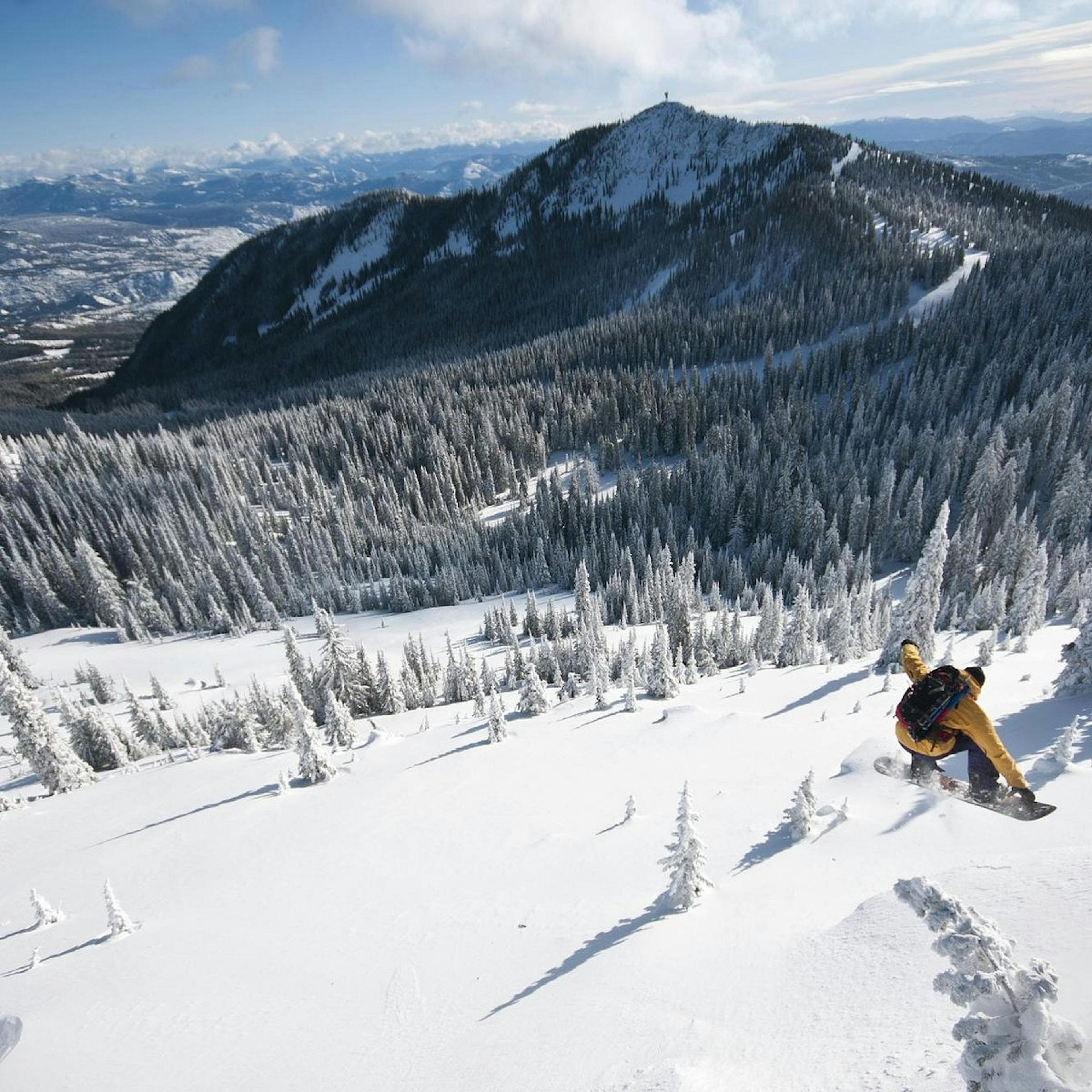 Snowboarder skiing the slopes at RED Mountain Resort