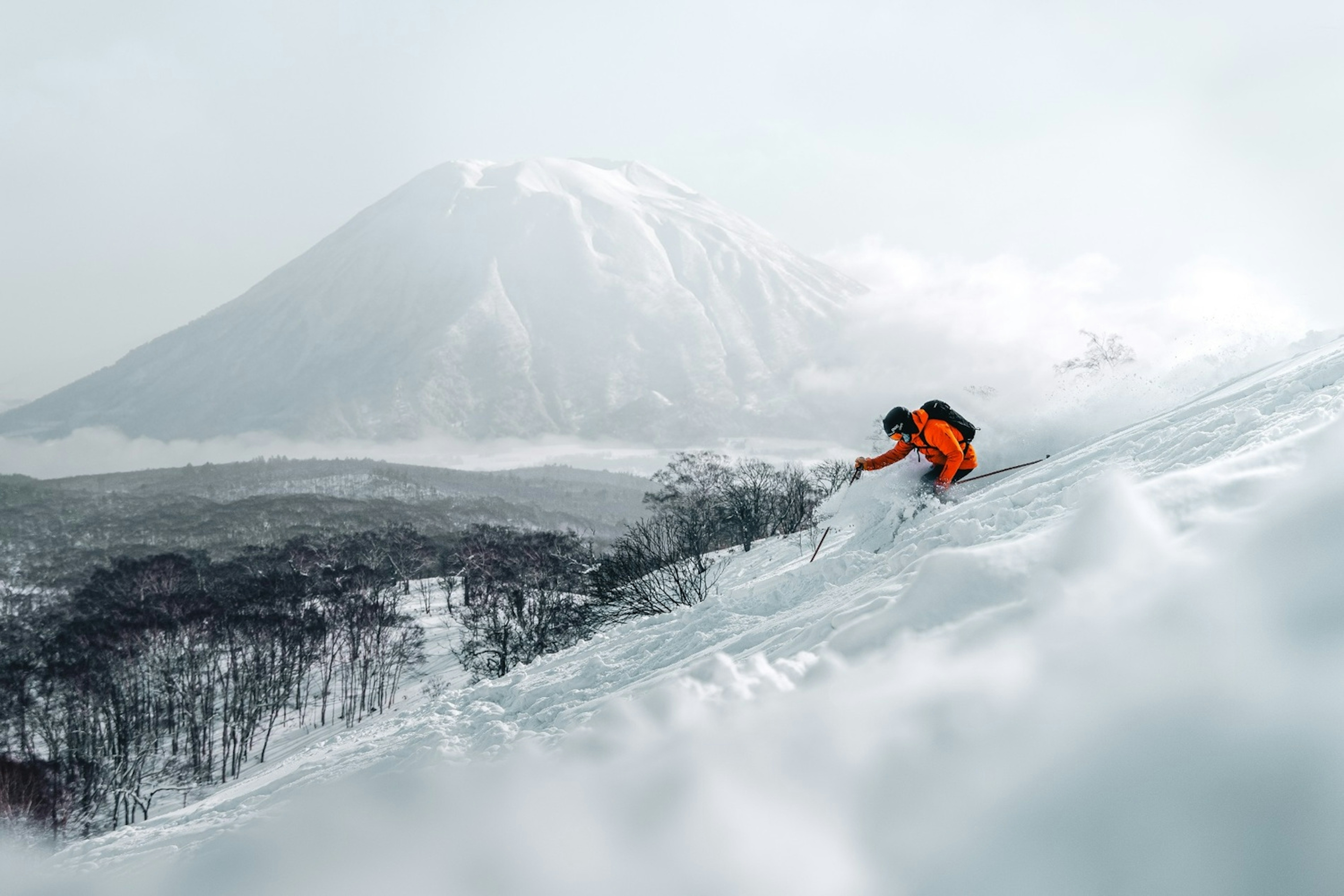 A skier skiing in powder snow in Japan.