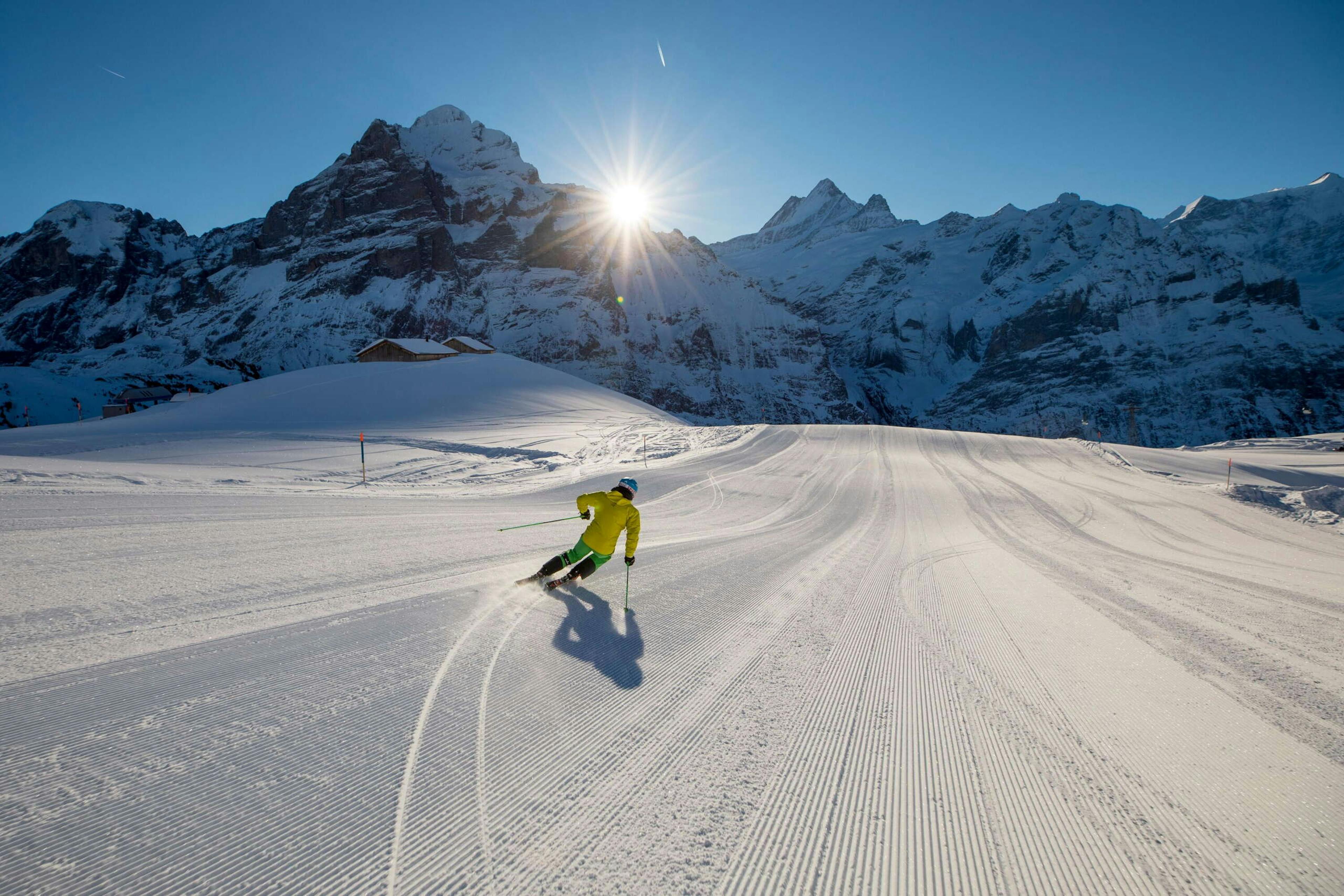 Skier in yellow jacket skiing the afternoon slopes at Grindelwald