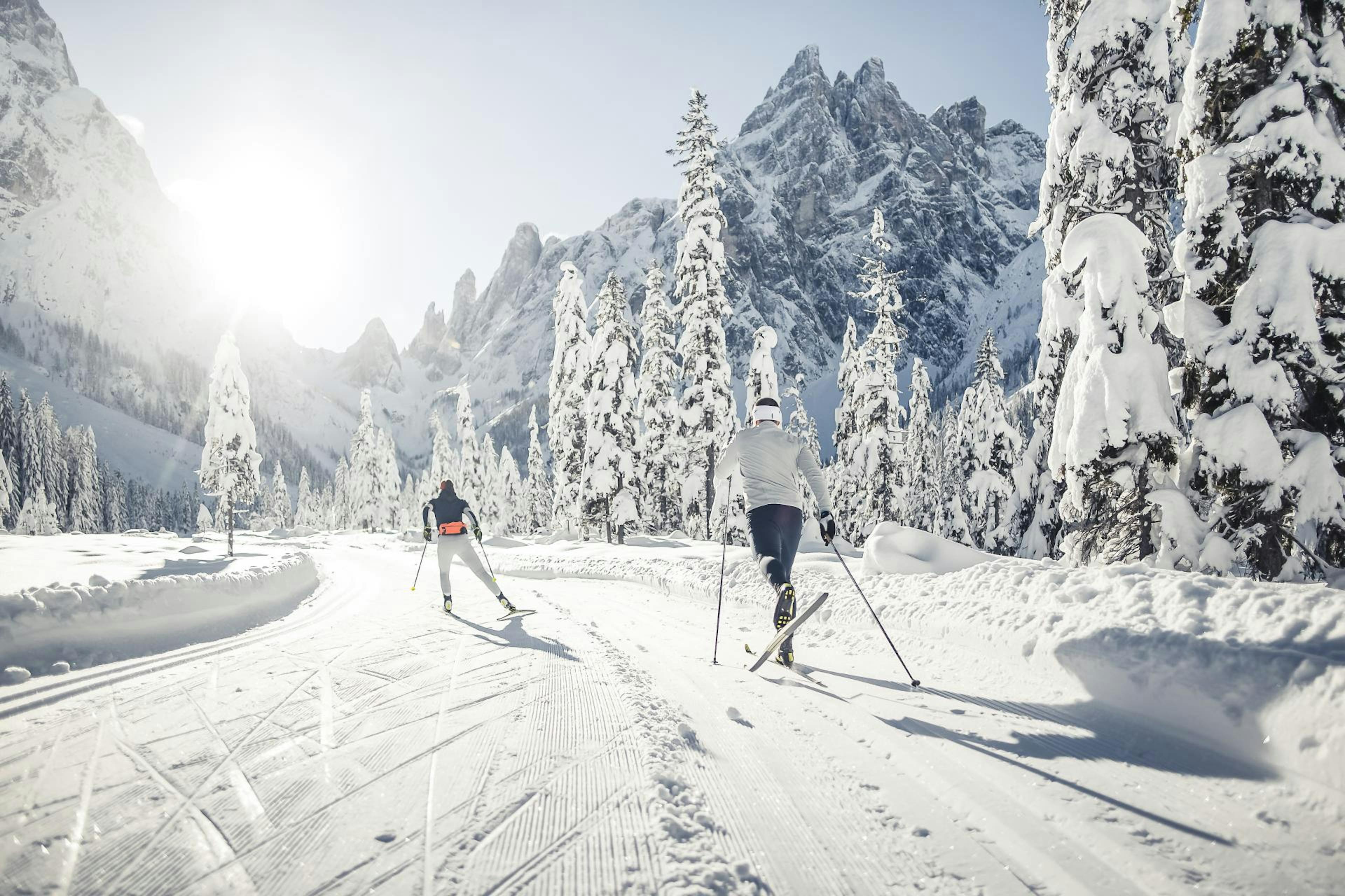 Two skiers skiing happily in Three Peaks in Italy