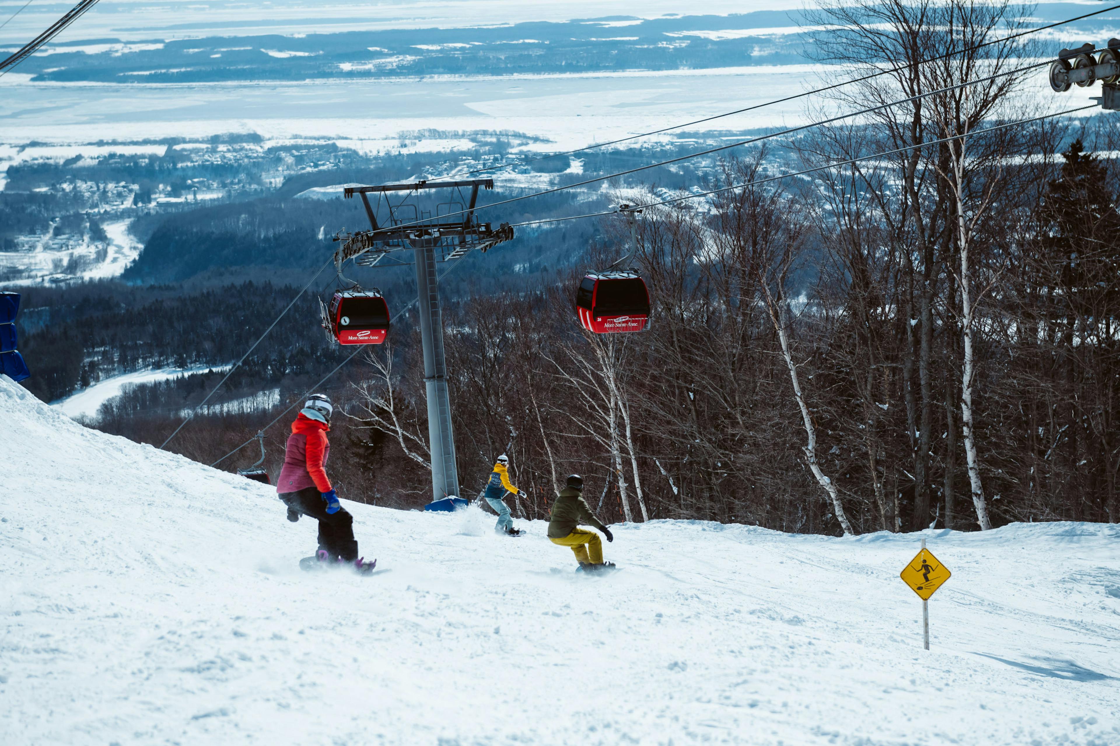 Skiers skiing down the slopes as the gondola runs in Mont Sainte-Anne