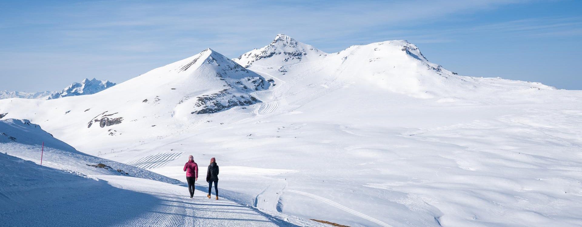 Two ladies walking through the mountains at Laax, Switzerland