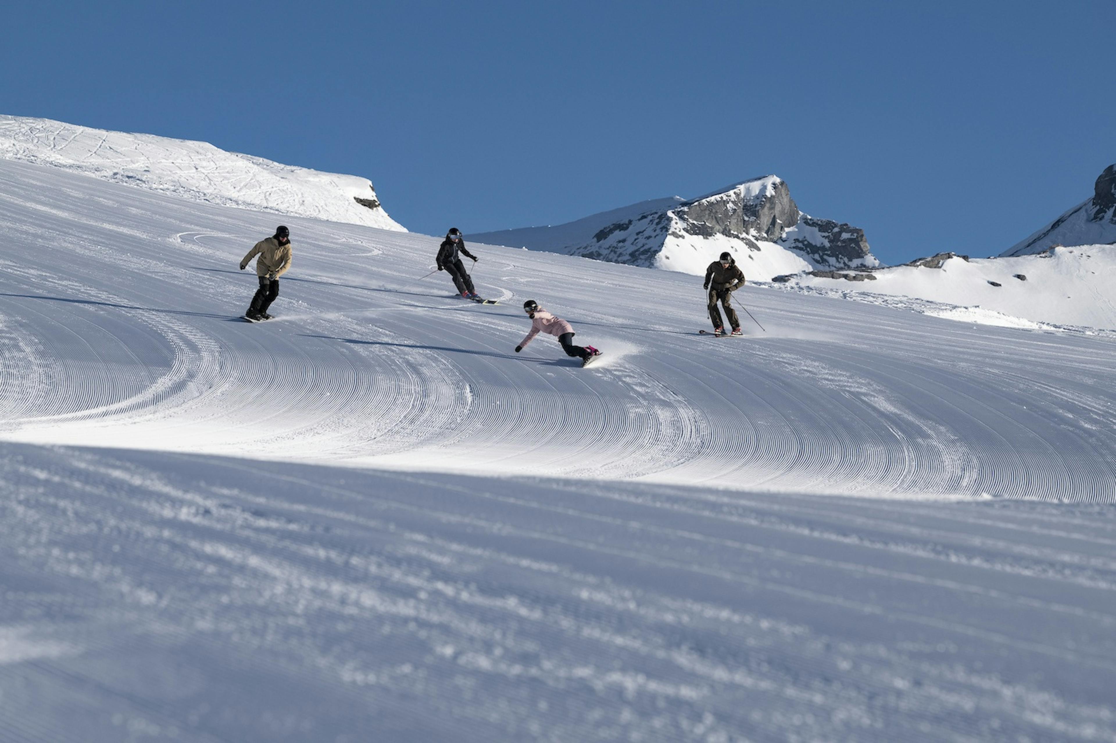 Four skiers skiing the slopes of Flims-Laax-Falera, Switzerland