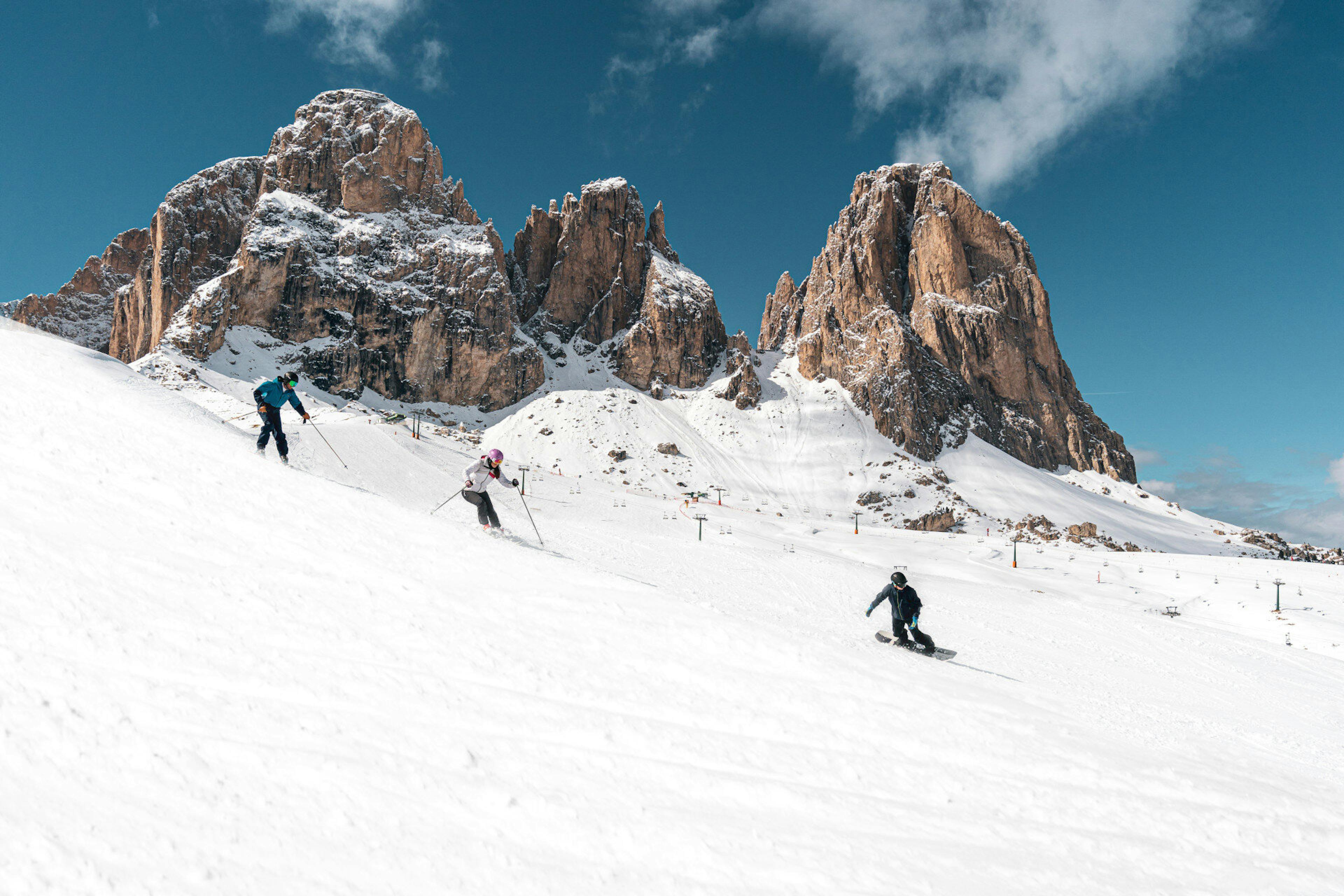 Skiiers hitting the slopes on a powdery afternoon in Val di Fassa in Italy