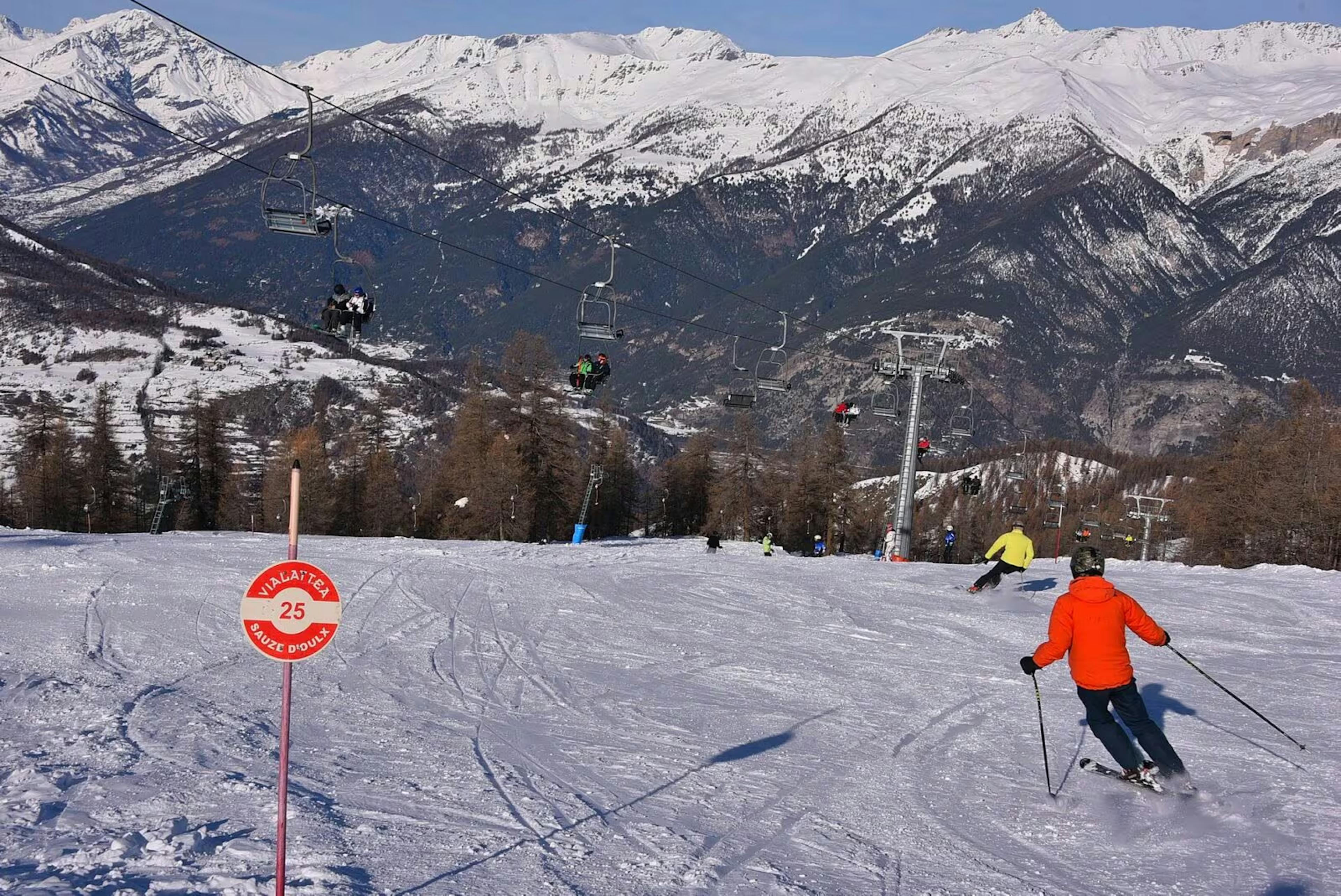 Man in orange ski jacket hitting the slopes at Sauze d'Oulx in Italy