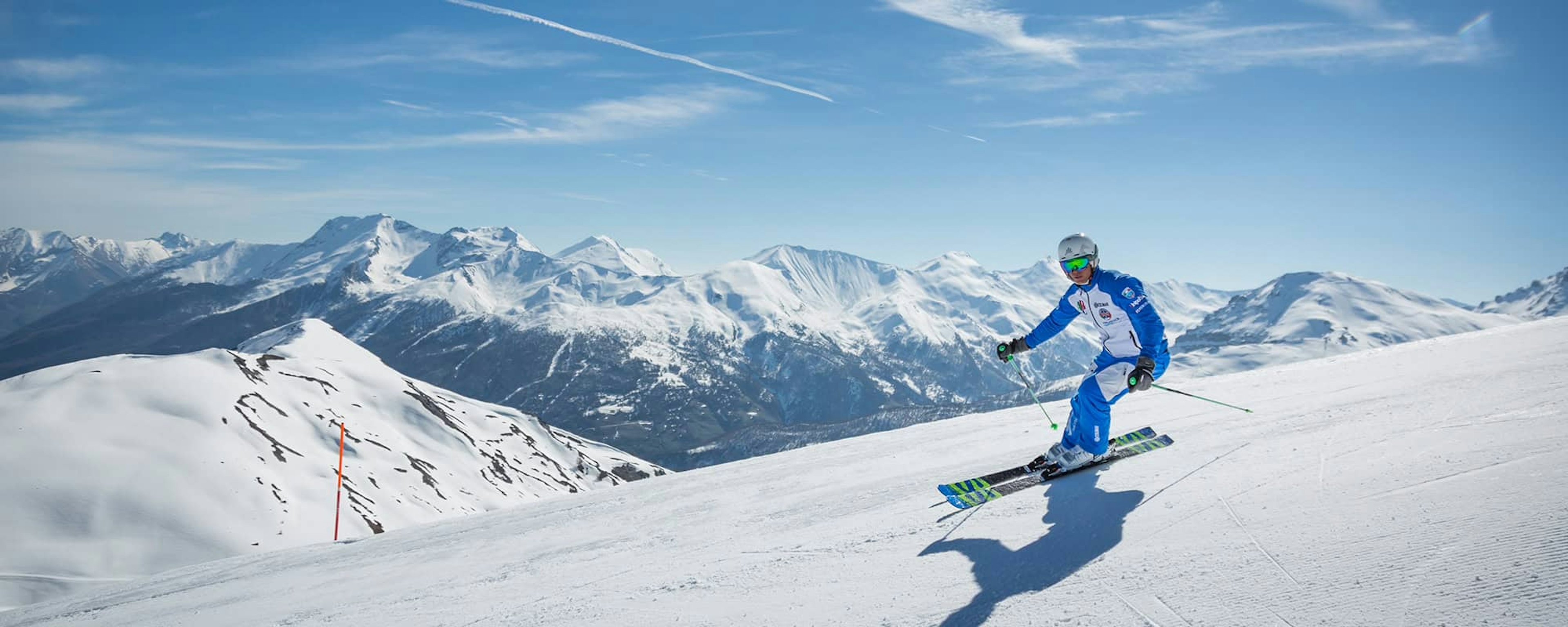 Male skier in blue ski suit hitting the slopes at Sauze d'Oulx in Italy