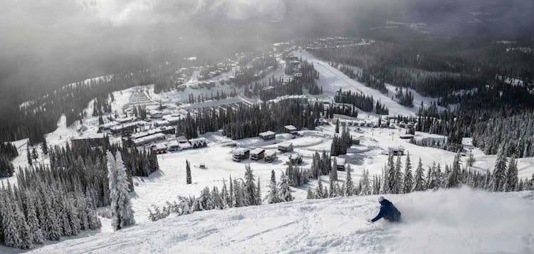Lone male skier hitting the morning slopes at Silver Star Mountain Resort in British Columbia, Canada at 