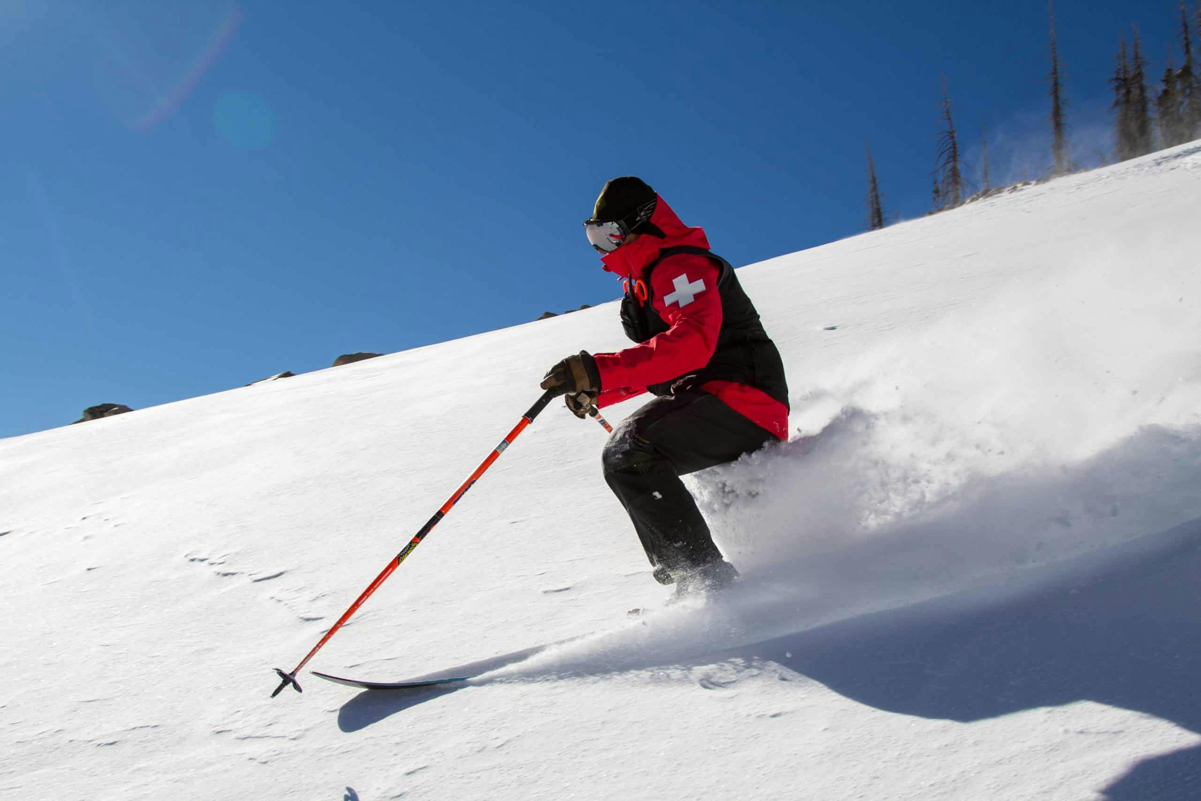 Male skier in red ski jacket skiing the slopes of Wolf Creek Ski Area in Colorado, U.S.