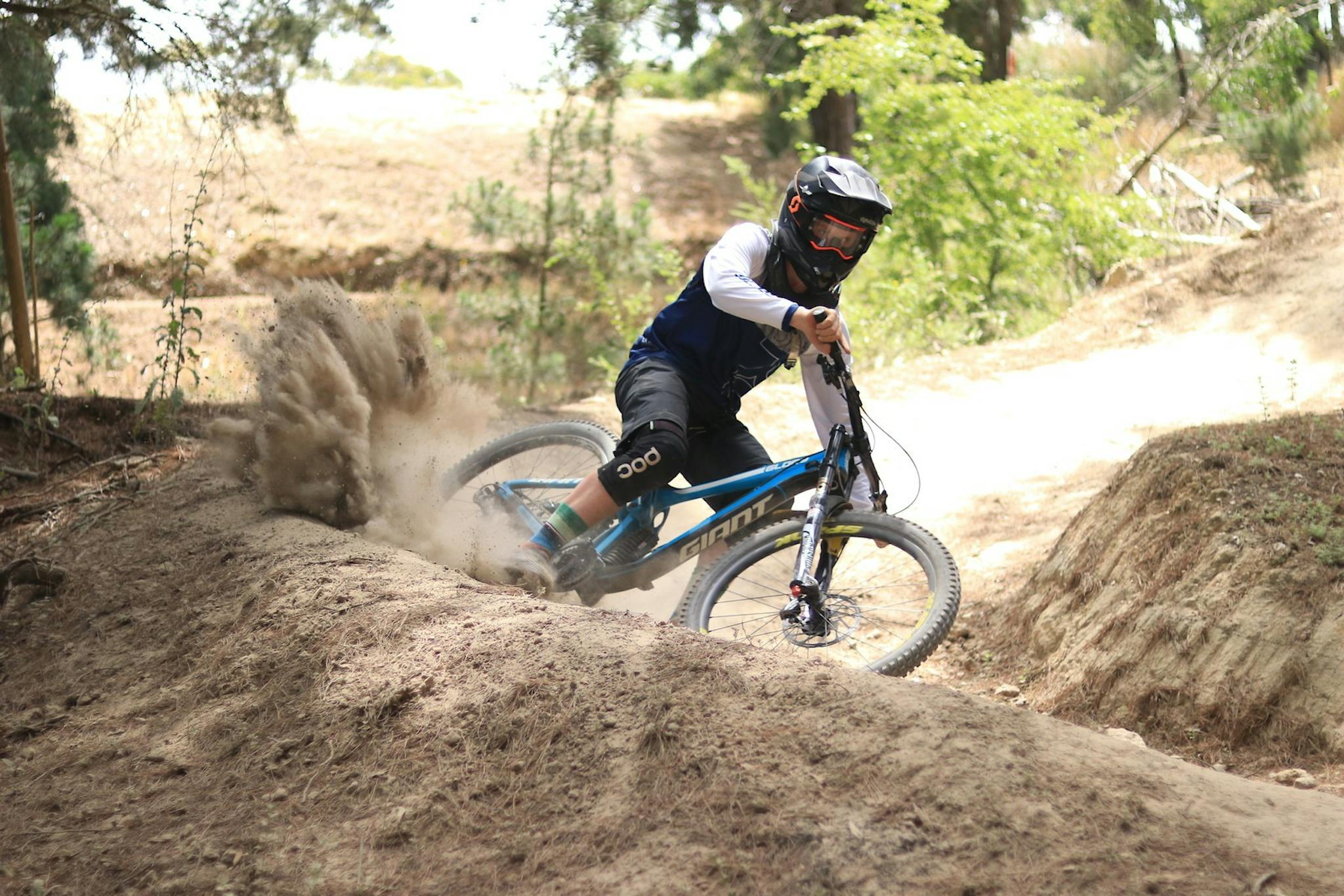 mountain biker rides a berm feature on a mtb trail