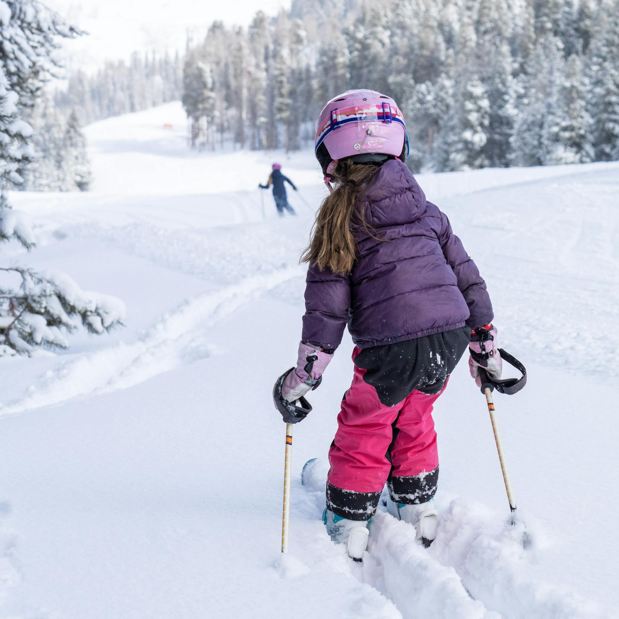 a child pushes through powder learning to ski at aspen snowmass