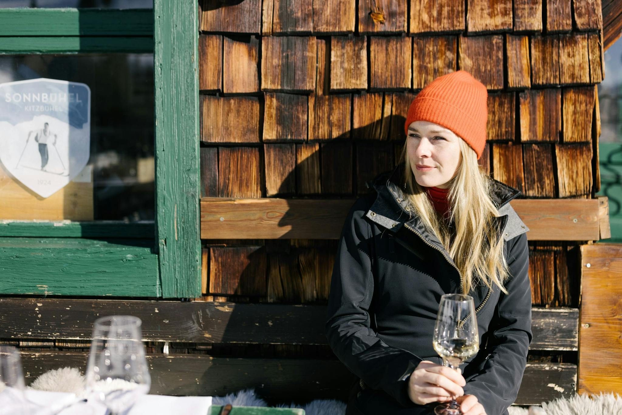 Skier sips her wine during après in Austria.