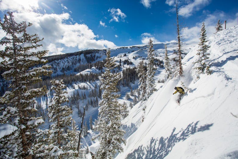 skier at the edge of a steep cliff at Aspen Snowmass extreme skiing