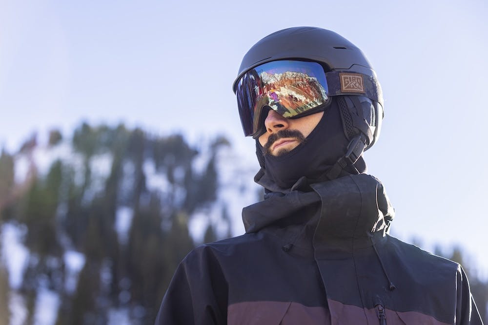 A man with a ski helmet and goggles, exuding confidence and excitement for a thrilling day of skiing.