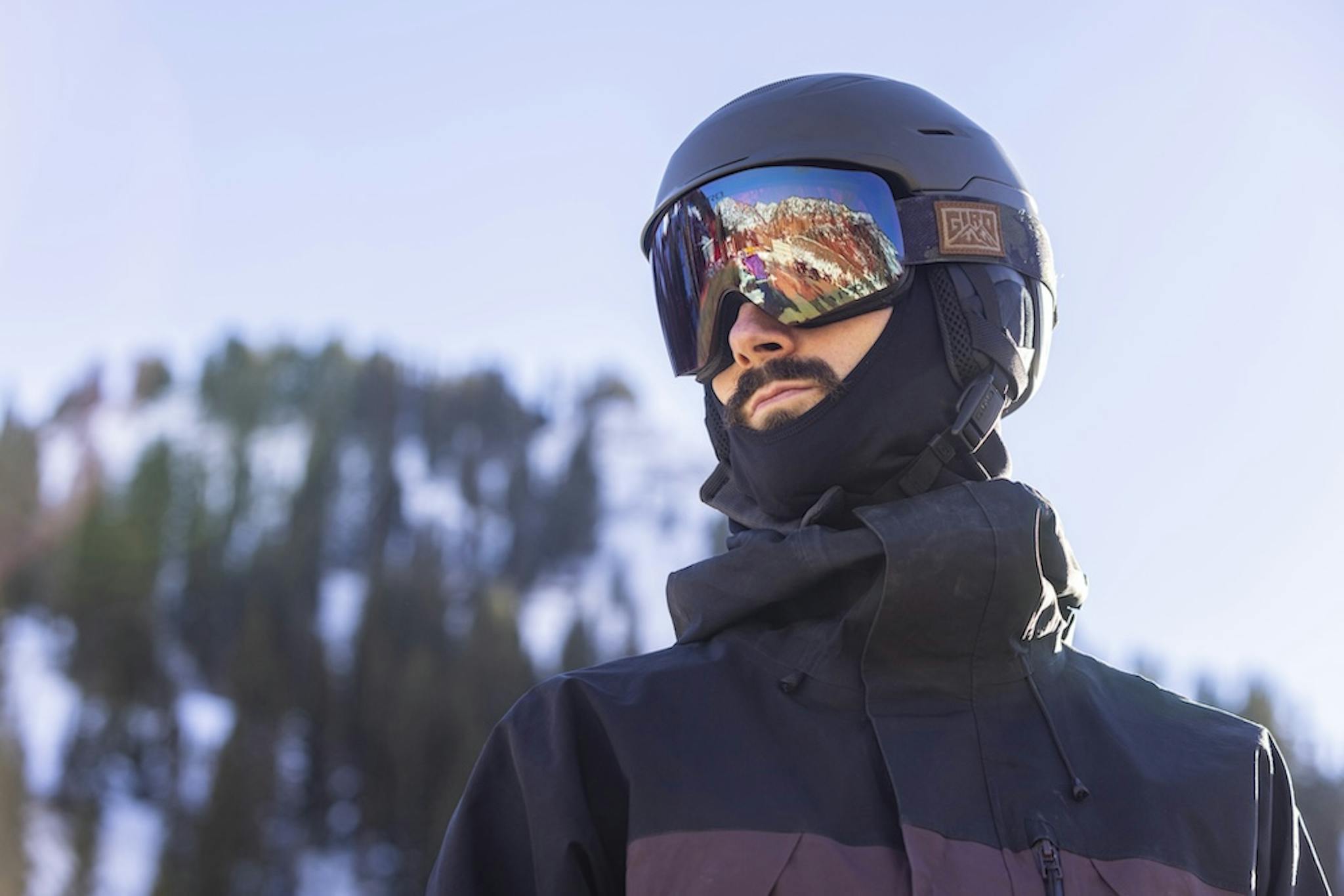  A man with a ski helmet and goggles, exuding confidence and excitement for a thrilling day of skiing.