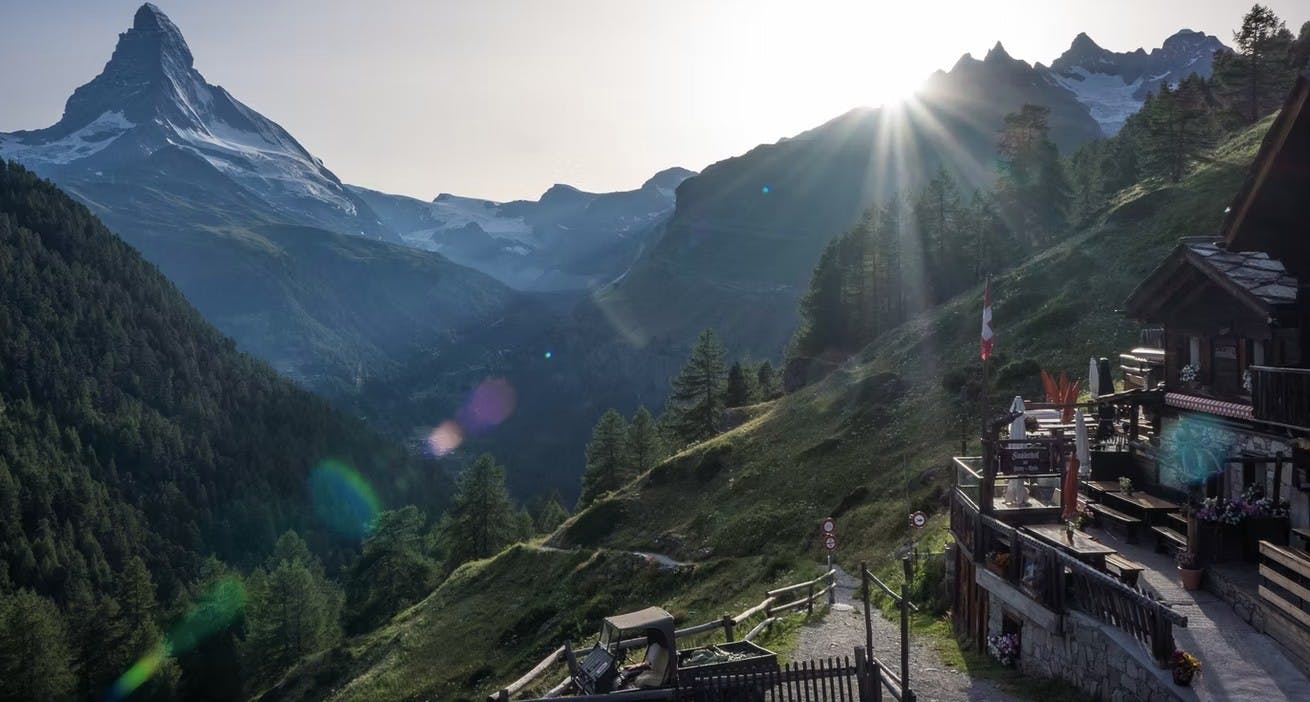The sun shines on the outdoor patio of Findlerhof with the Matterhorn peak in the backdrop