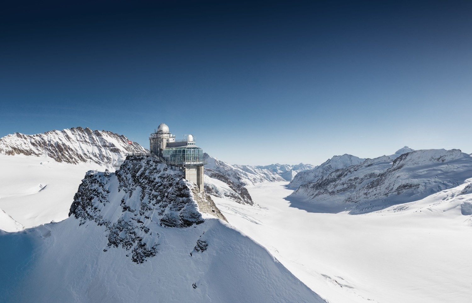 A tower sits on top of a mountain in the snow at jungfraujoch switzerland