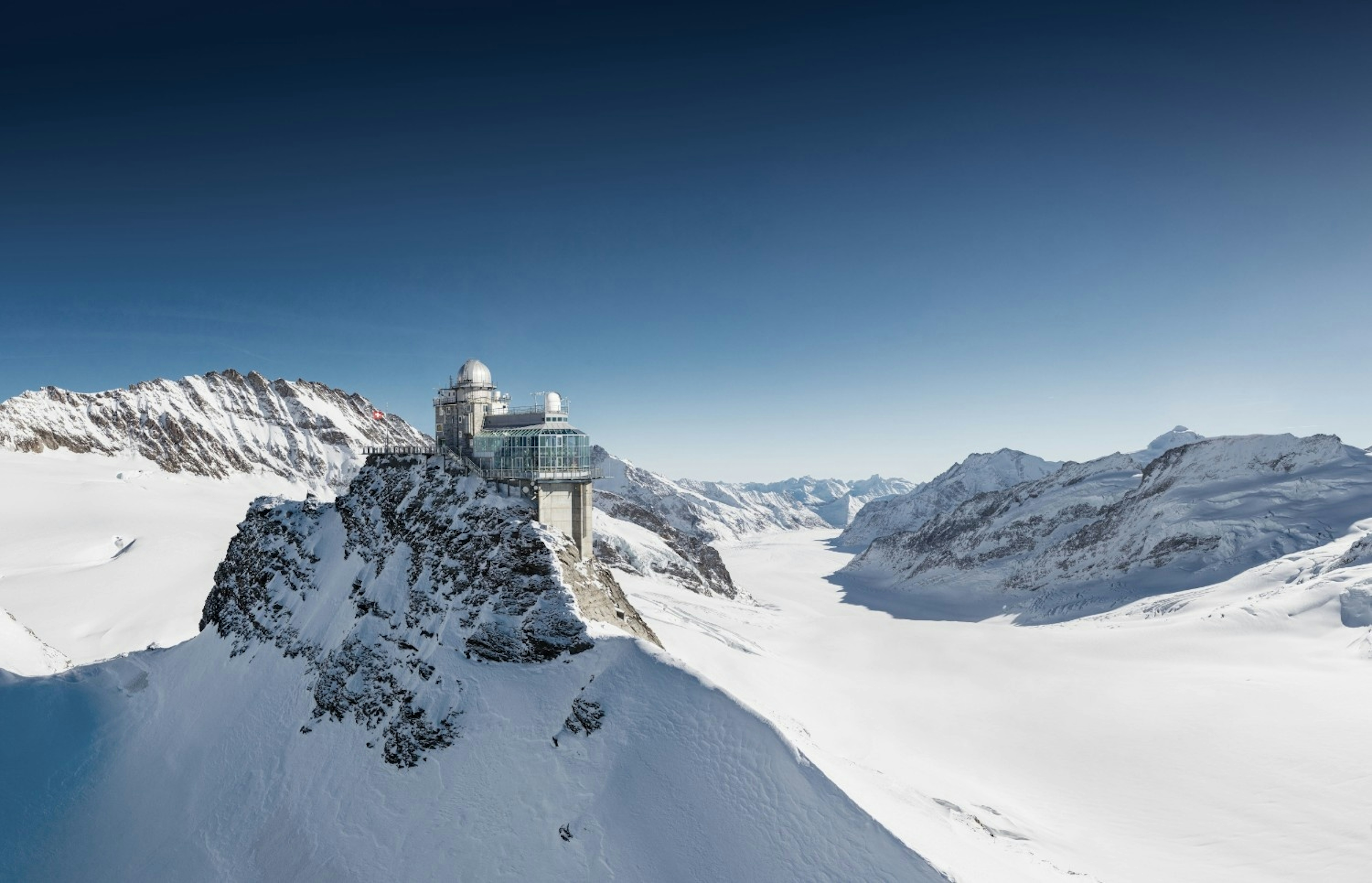 A tower sits on top of a mountain in the snow at jungfraujoch switzerland
