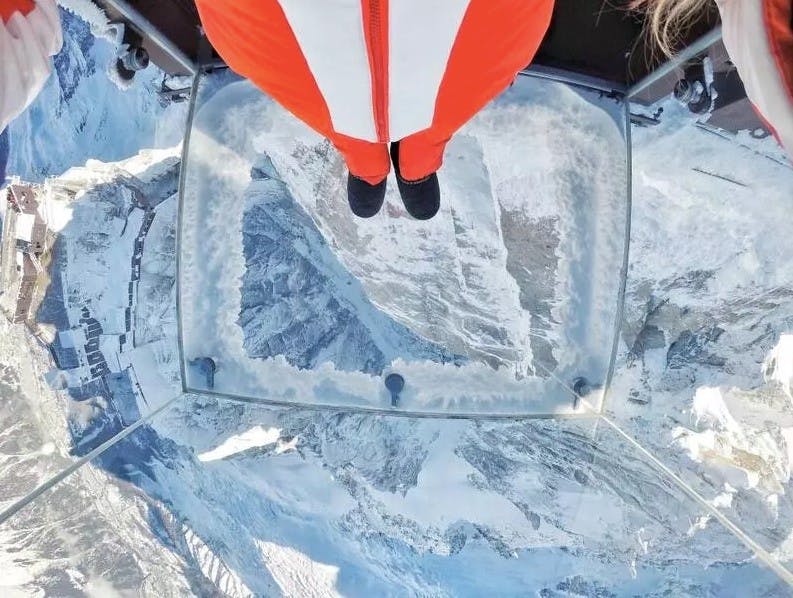 Two feet standing on the glass floor of the glass cube called The Void or Le Pas dans le Vide in France
