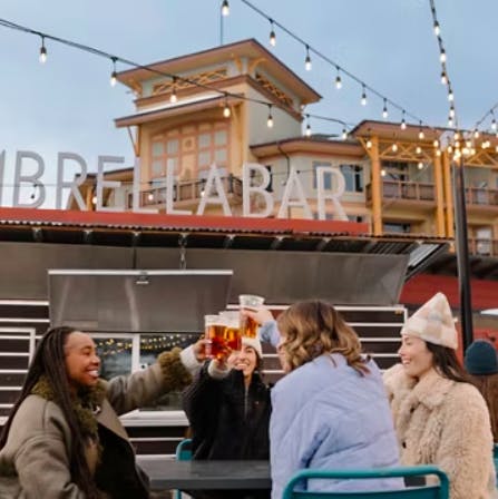 Group of 4 women cheers during a bachelorette party on the patio at the Umbrella Bar at Park City Resort