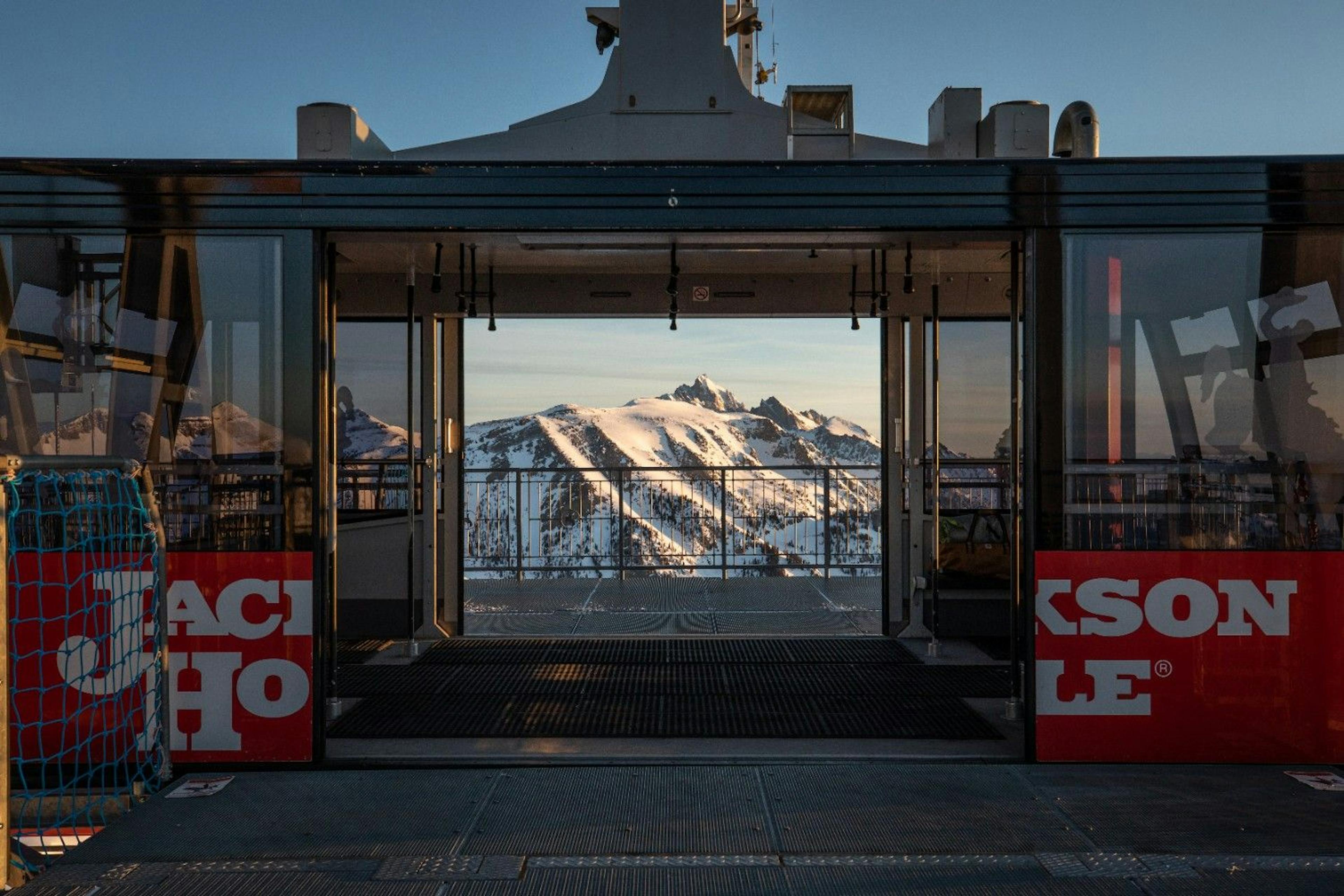 Jackson Hole Tram with open doors and a beautiful view of the snowy alpine mountains