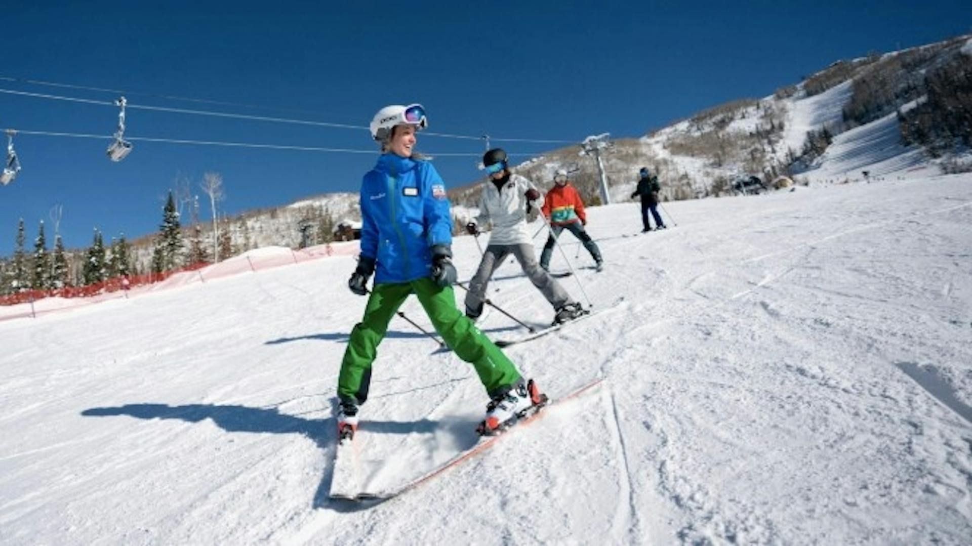 A Steamboat ski school instructor teaching 3 beginner skiers how to do the "pizza" to slow down on a ski run at Steamboat Springs resort