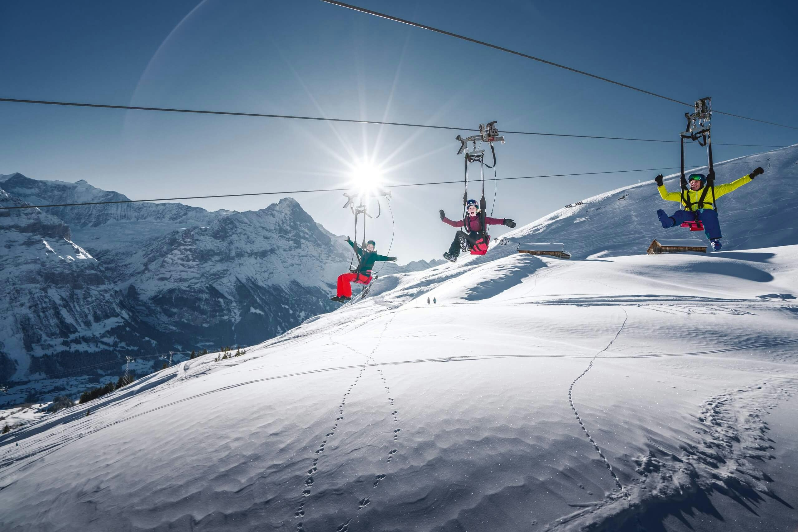 Three people running the zipline near Interlaken in the Jungfrau region of Switzerland.