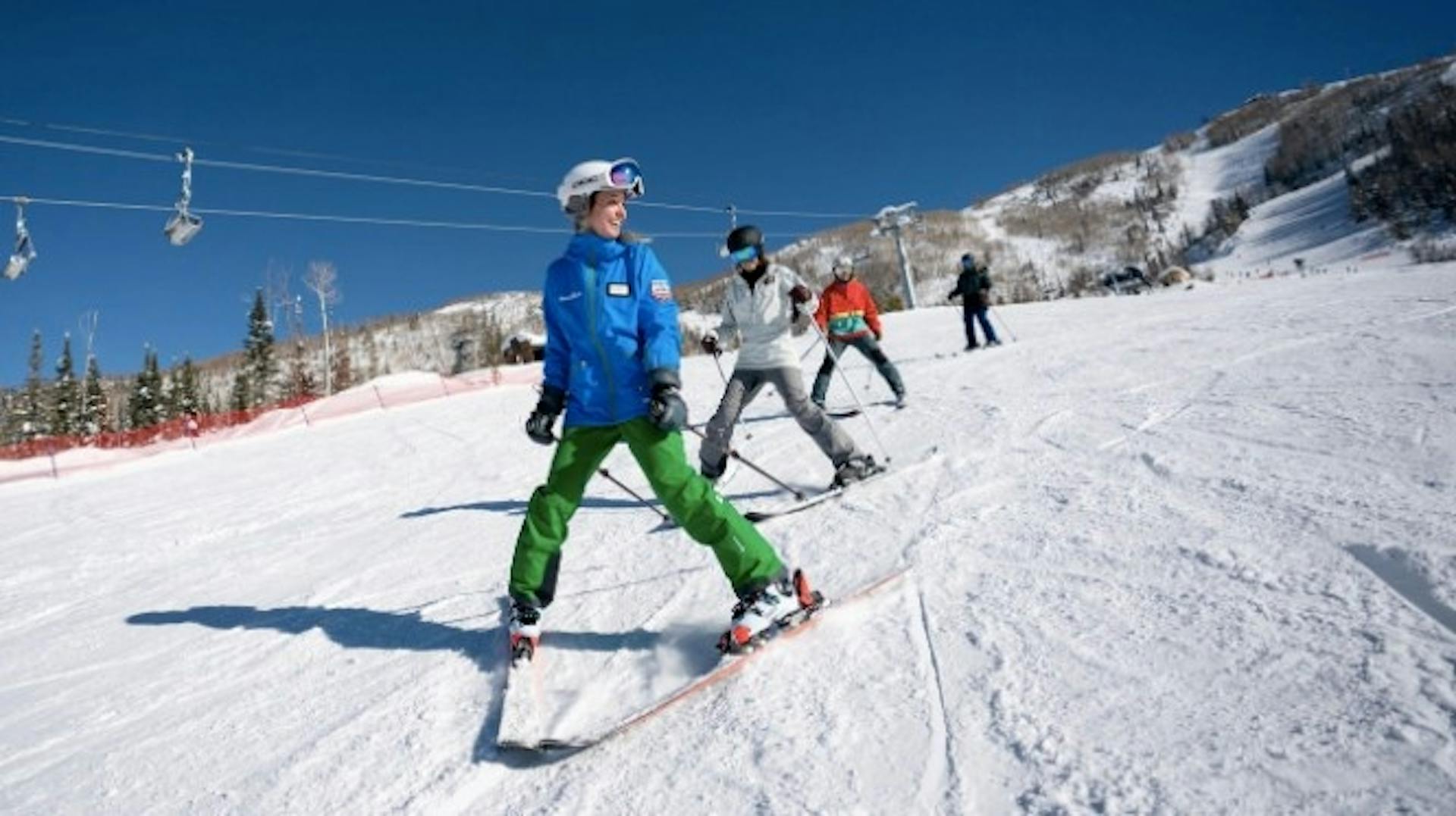 Steamboat Springs ski school instructor teaching skiers how to do the pizza on a downhill slope