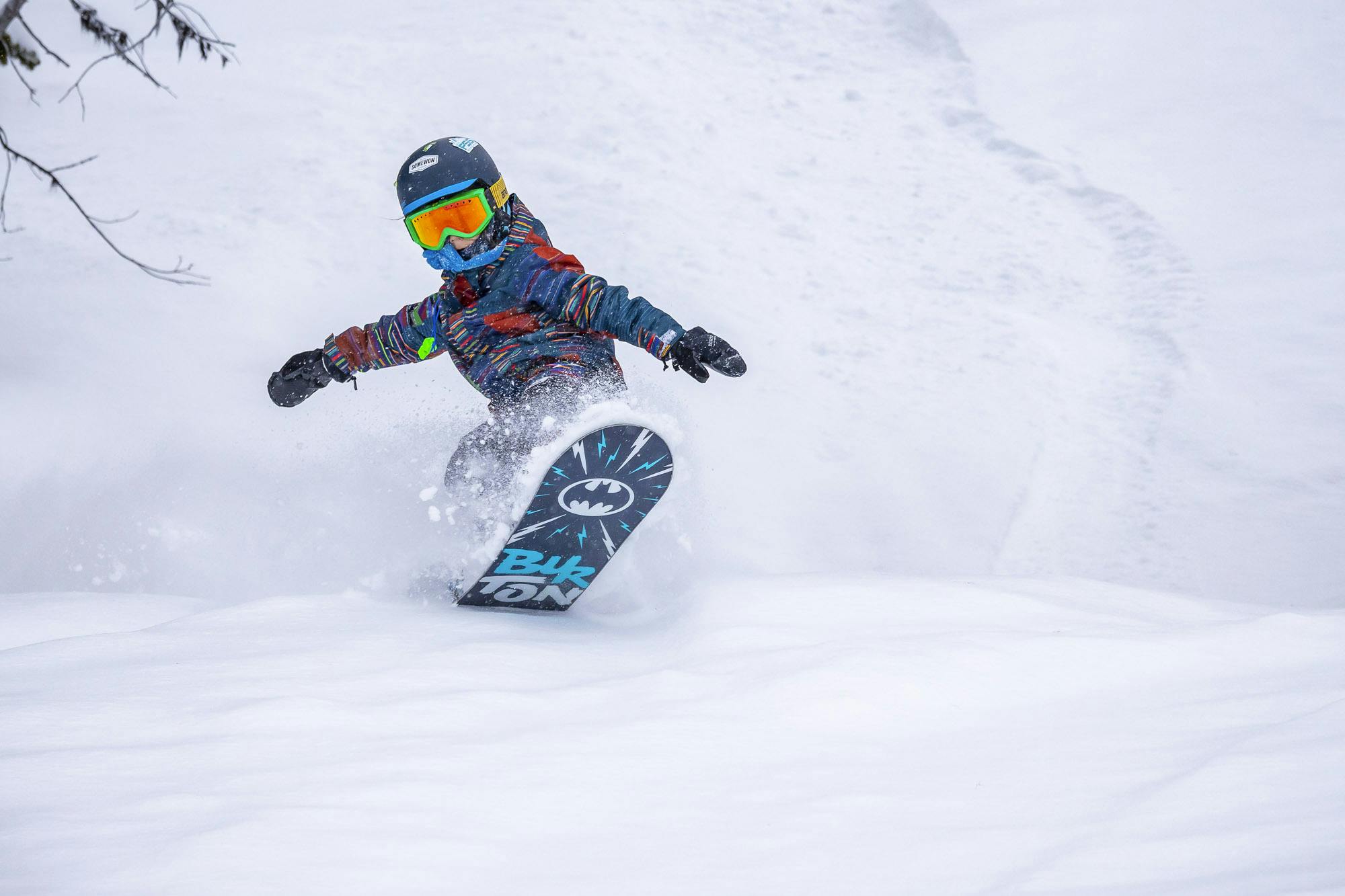 Young kid snowboarding in powder at Revelstoke Resort in Canada