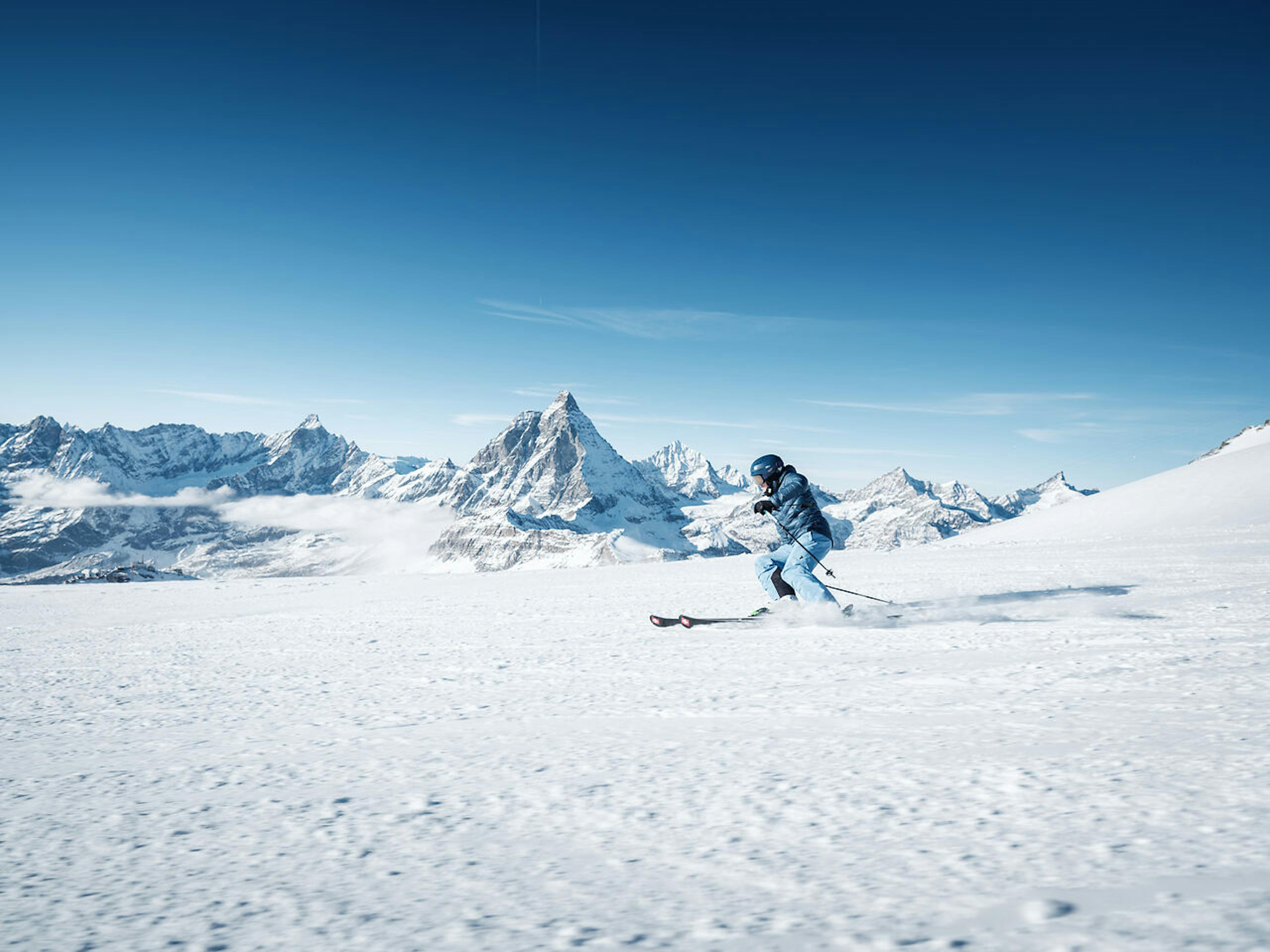 skier skiing at Zermatt Ski Resort with the snowy Matterhorn mountain behind them