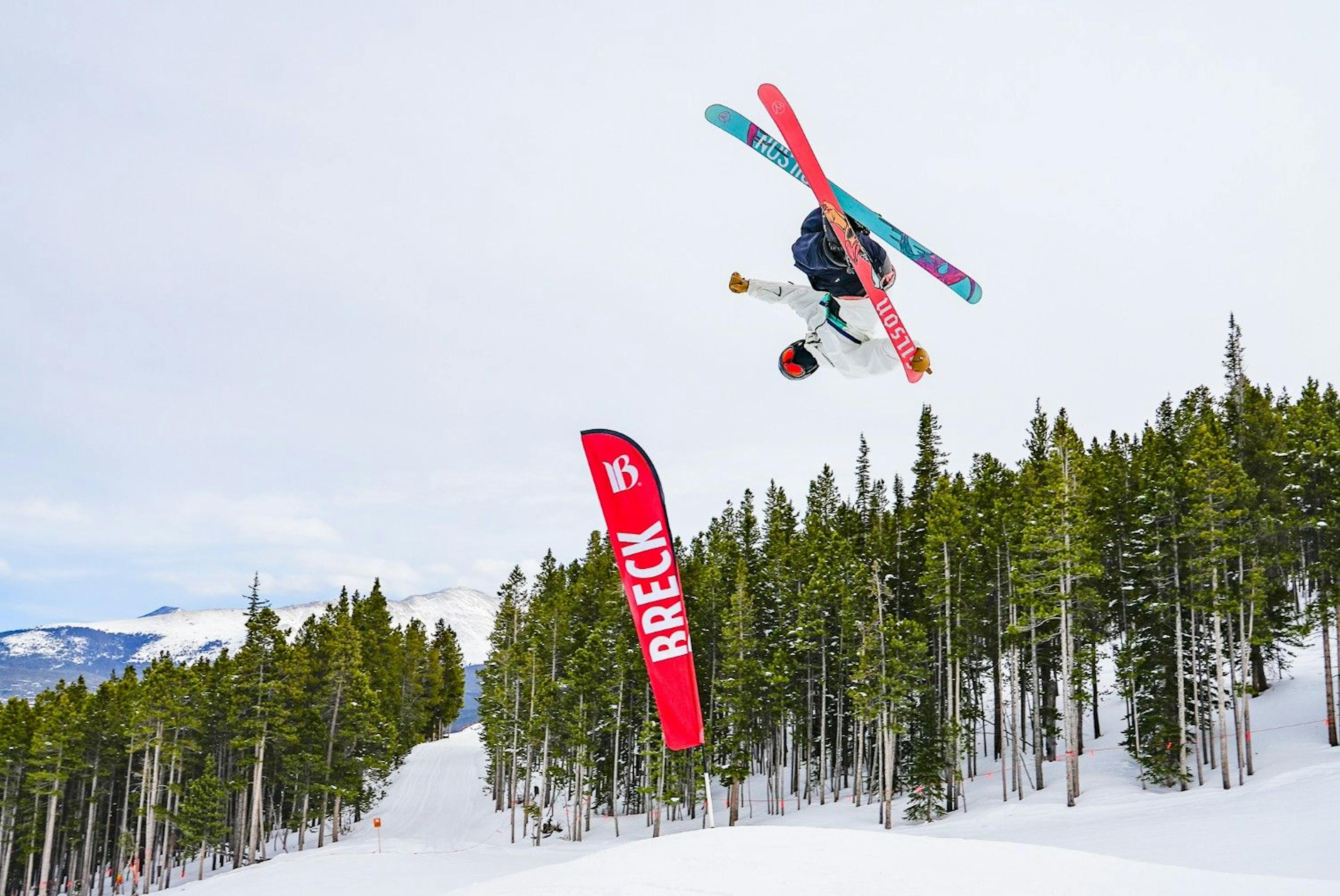 Skier does a cross trick in mid-air at the Breckenridge terrain park